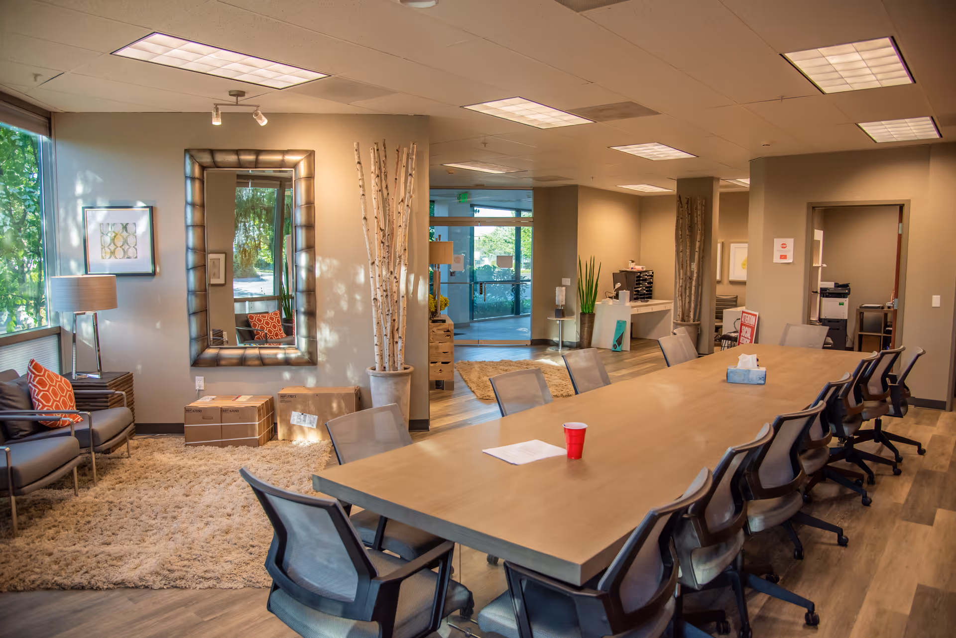 Large conference table with chairs in a spacious lounge area of a senior facility.