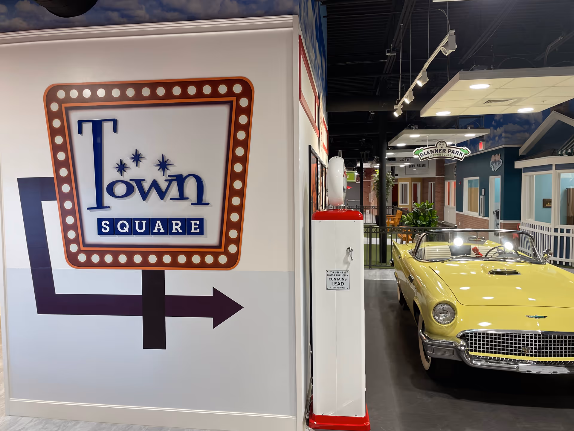 Indoor Town Square Sarasota Senior Day Care display with retro signage and a yellow convertible.