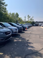 Line of parked cars along a sunlit MobilityWorks outdoor parking lot.