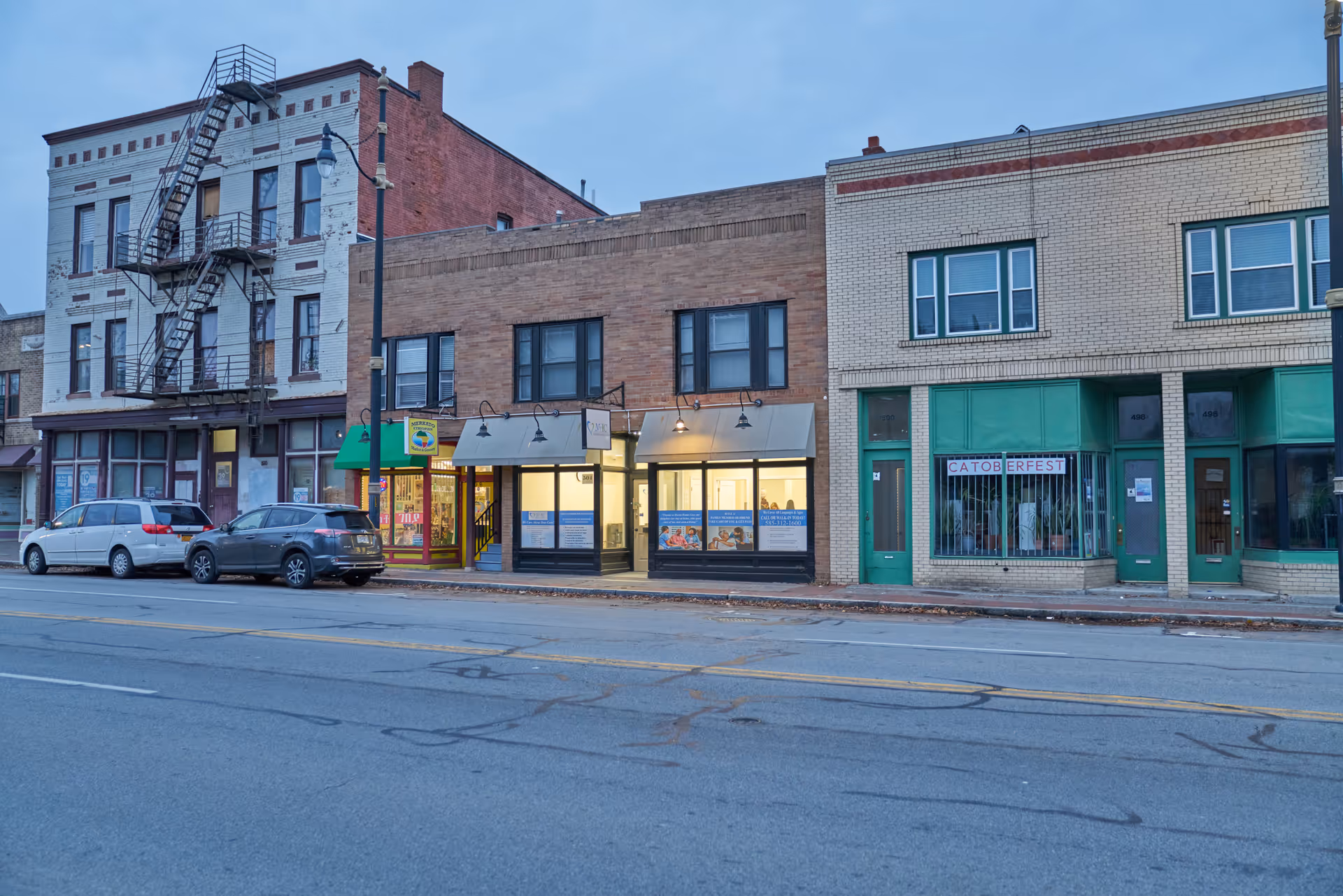 Row of brick storefronts along a street; no people visible.