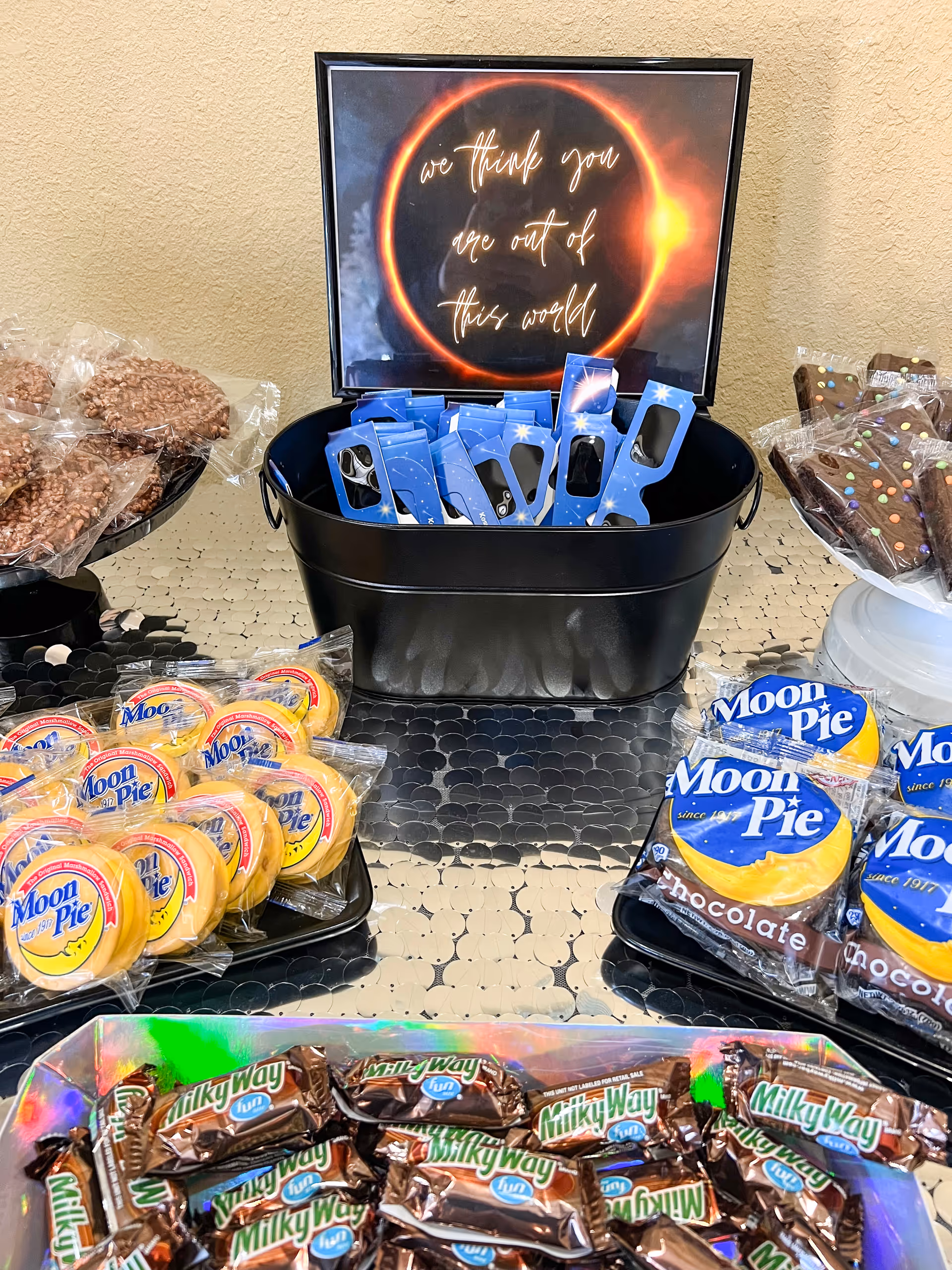Snack display with Moon Pie and Milky Way chocolates on a tiled counter indoors