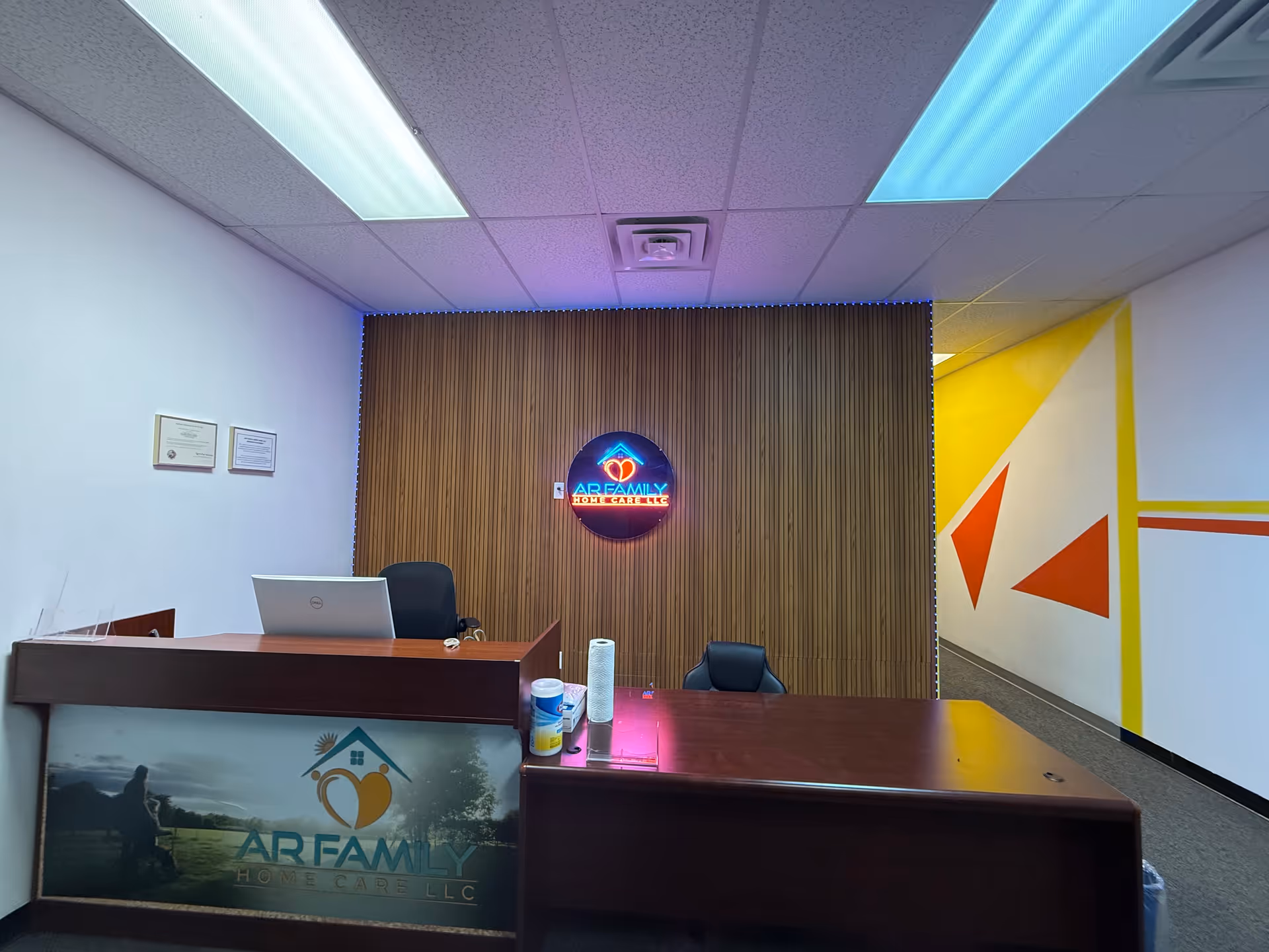 Reception desk in a modern AR Family Home Care LLC lobby with logo wall.