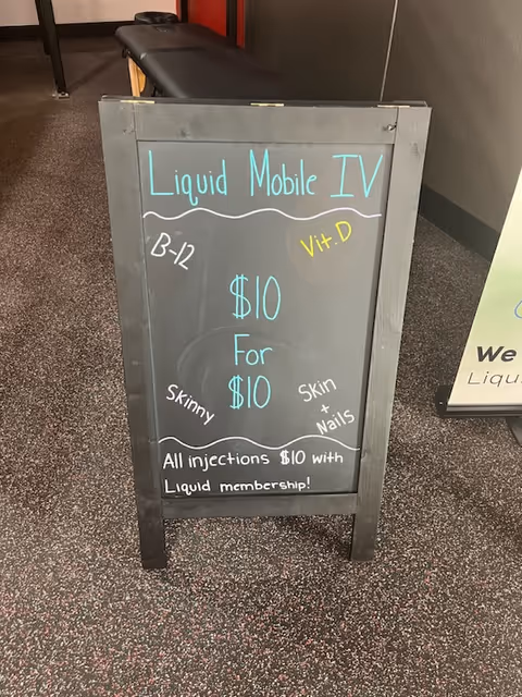 Chalkboard sign advertising Liquid Mobile IV in a hallway at a senior facility.