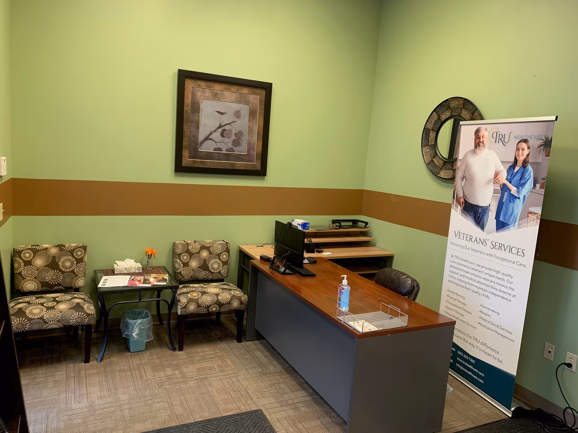 Reception area inside TRU Healthcare with a desk, chairs, and banner.