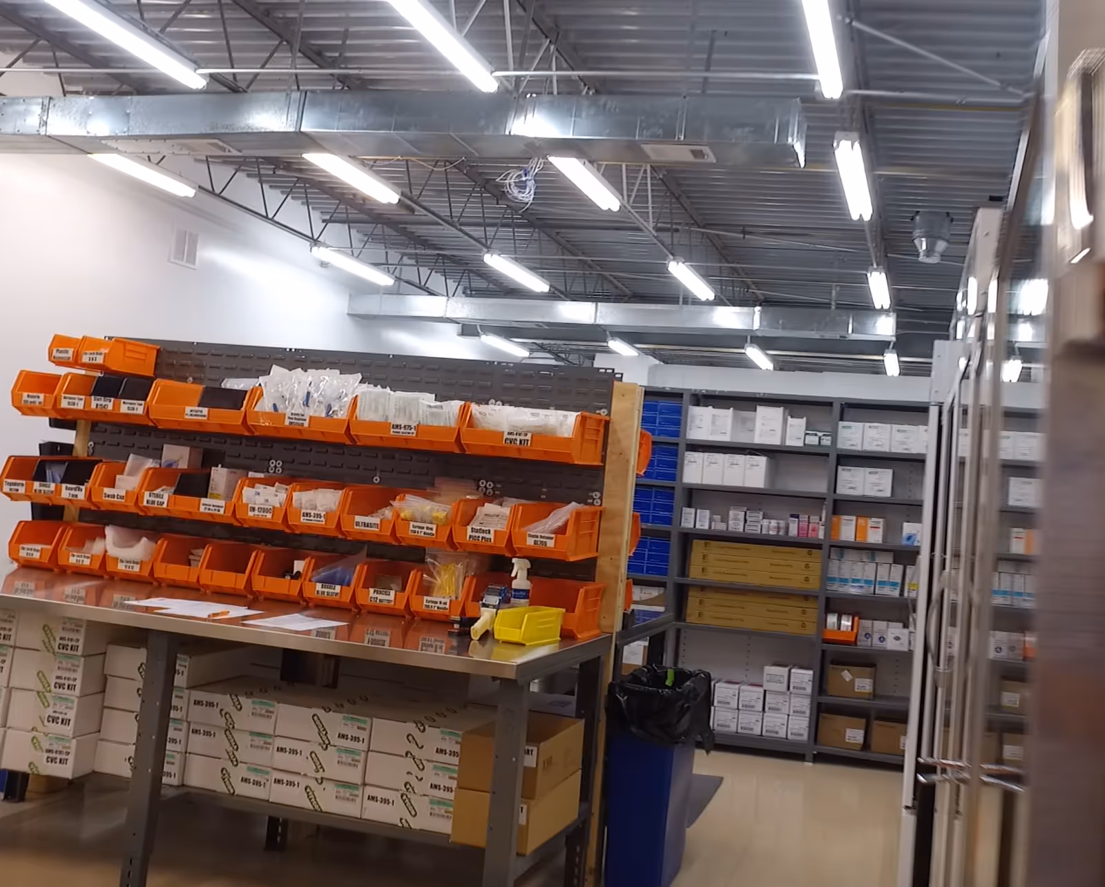 Industrial storage room with orange labeled bins and metal shelves