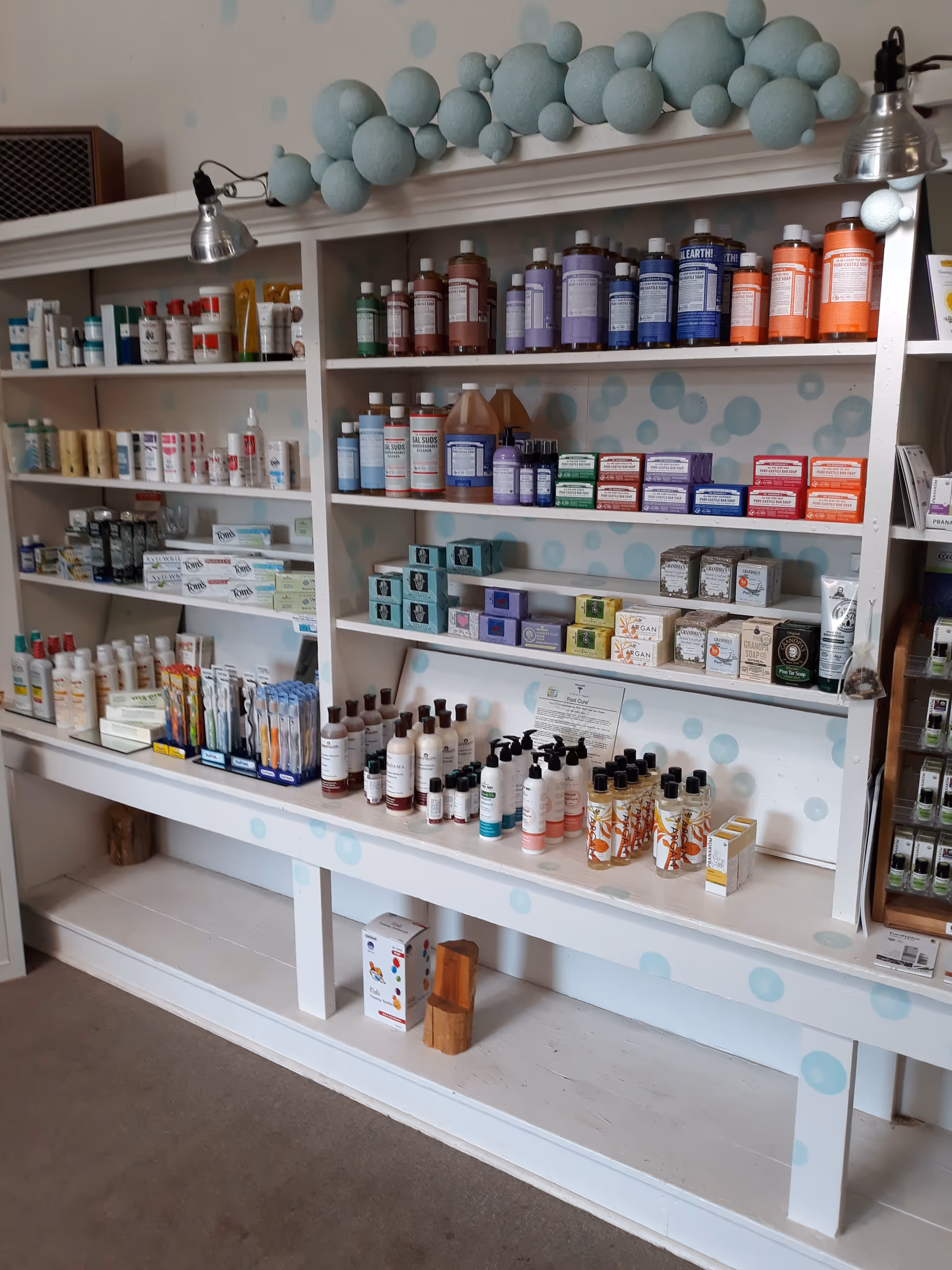 Bright interior with extensive shelves stocked with medicines, toiletries, and wellness products in a retail-like setup.
