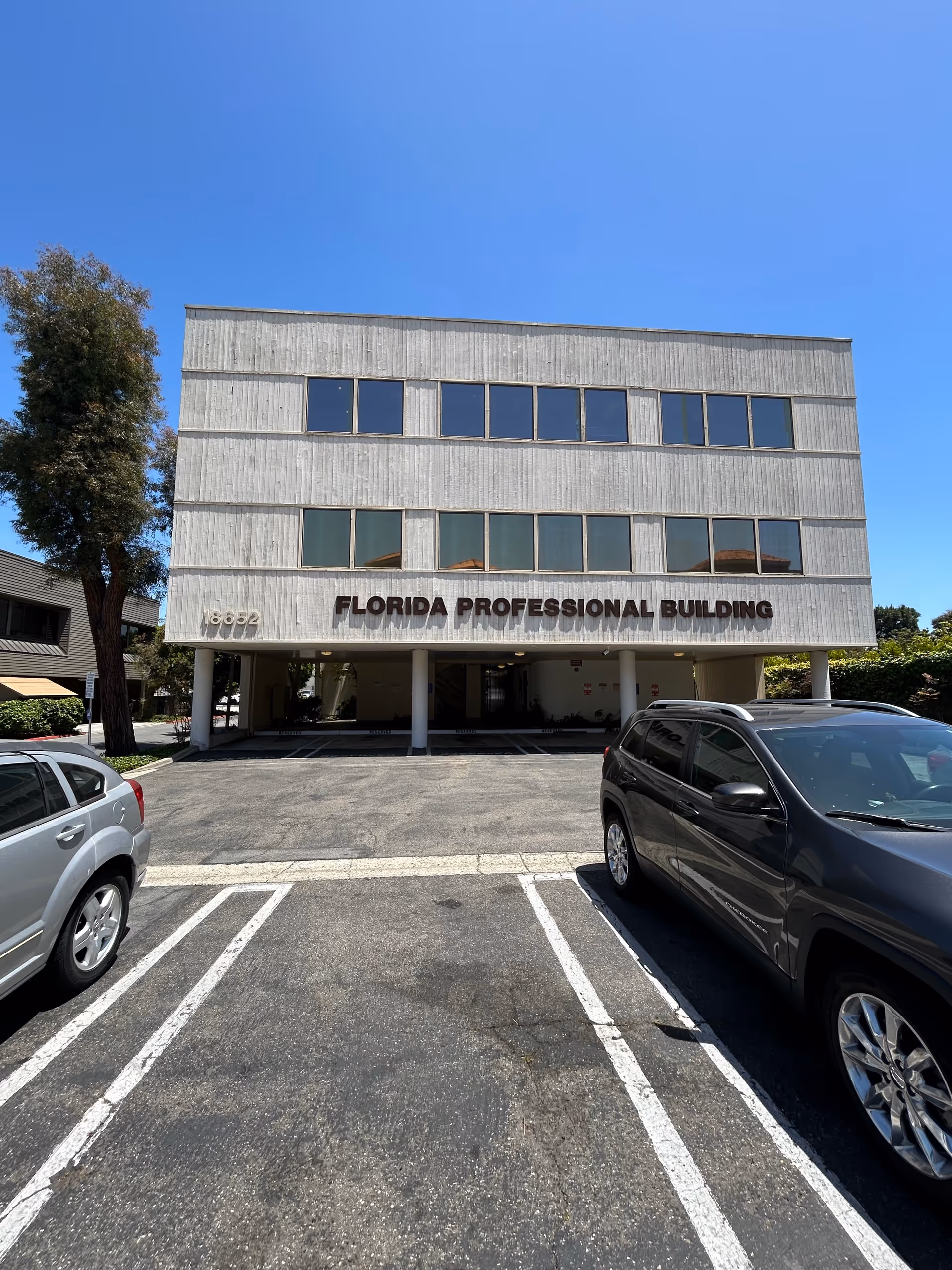 Parking lot in front of a three-story concrete building labeled Florida Professional Building.