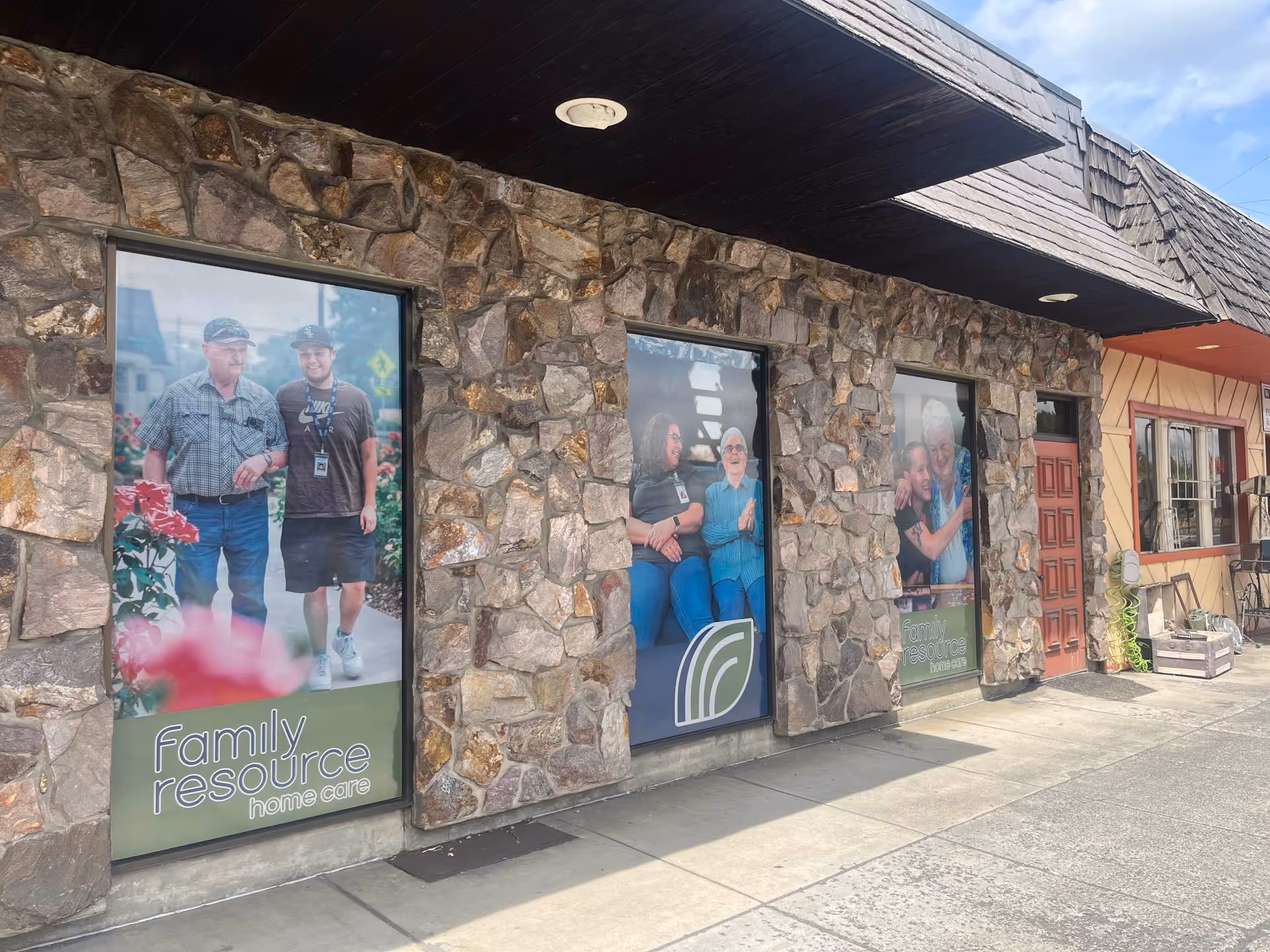 Stone storefront displays large posters advertising Family Resource Home Care outside the office.