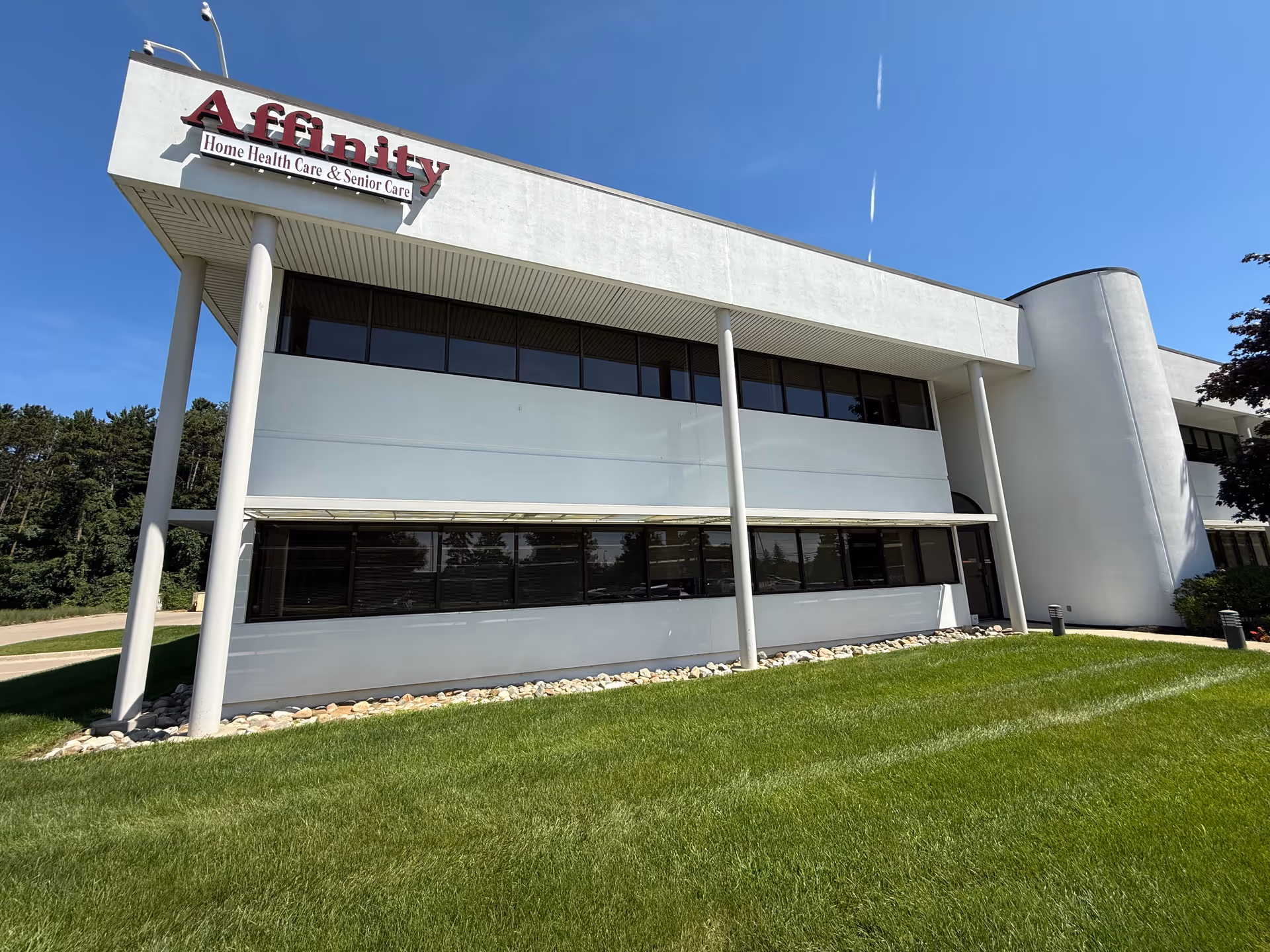 Modern white Affinity Senior Care building exterior with tall columns and large windows.