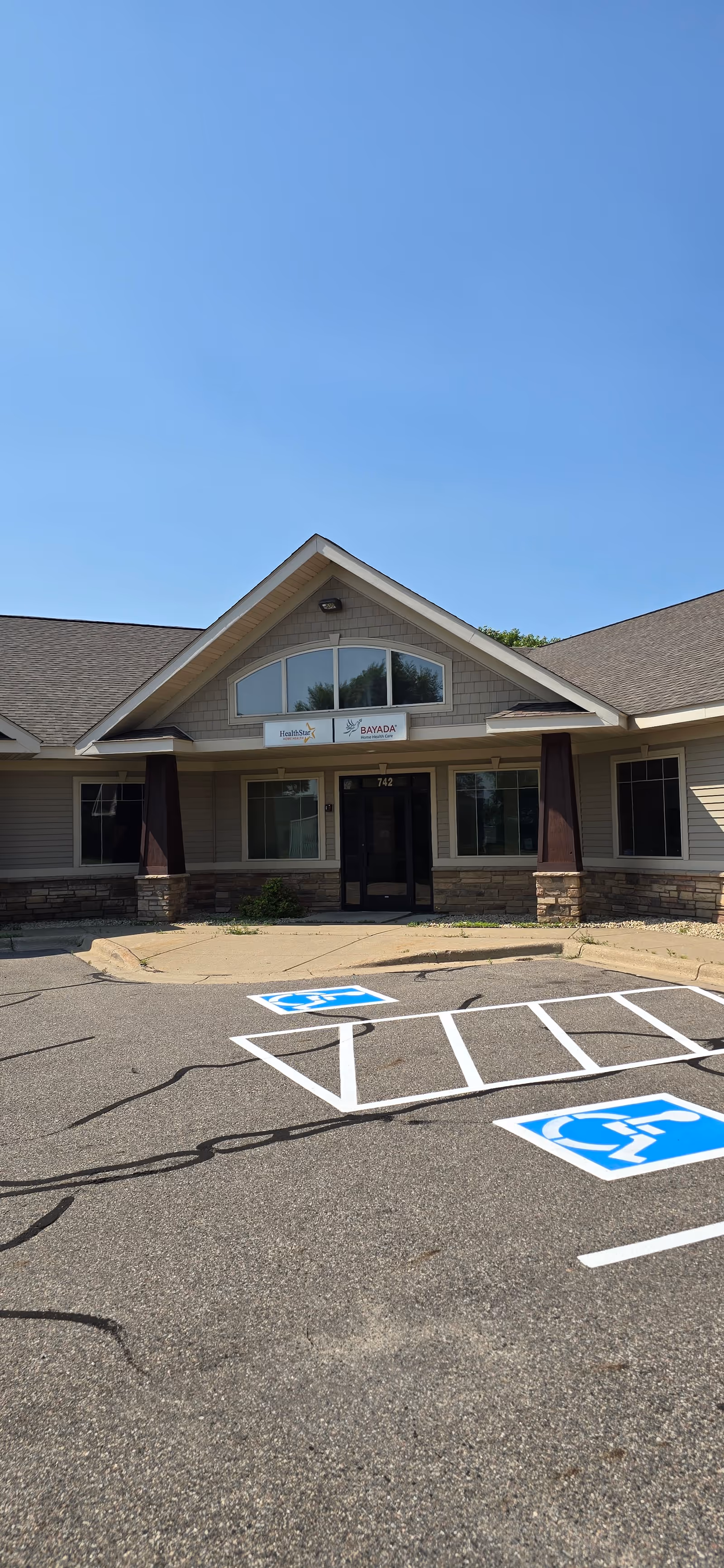Front view of a BAYADA Pediatrics facility entrance with a parking lot.