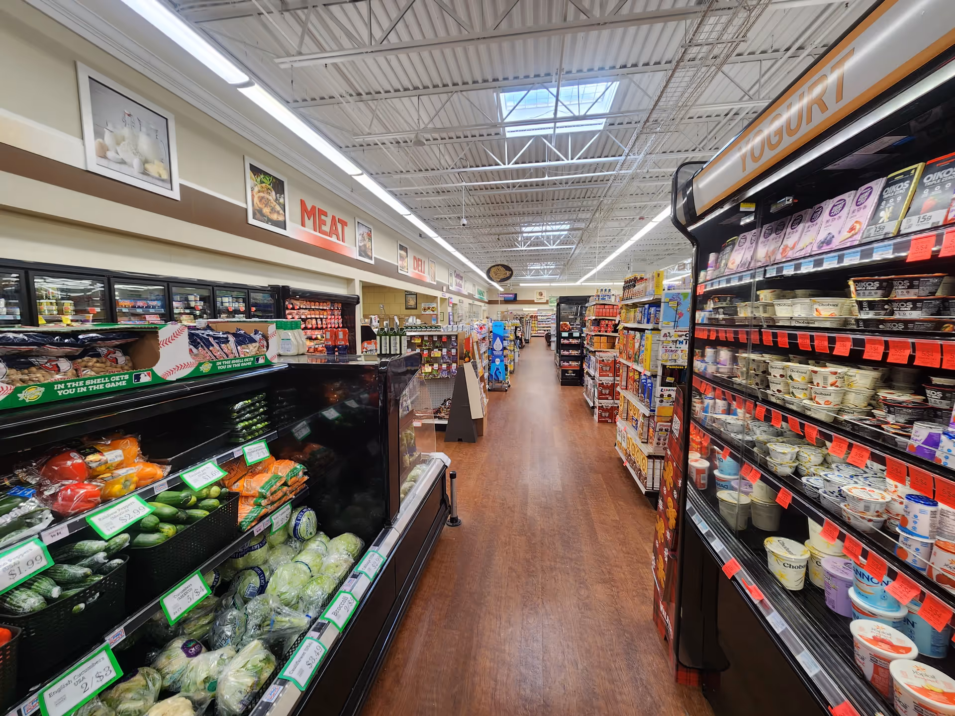 Aisle inside a Discount Drug Mart store with meat section, shelves, and yogurt on the right.