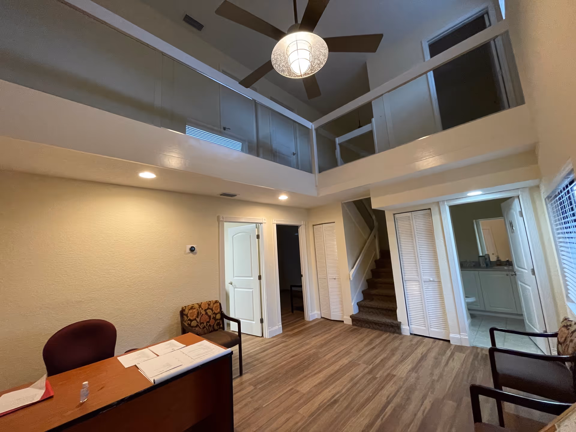 Reception area of Angie’s Senior care & staffing with desk, chairs, stairs, and loft.