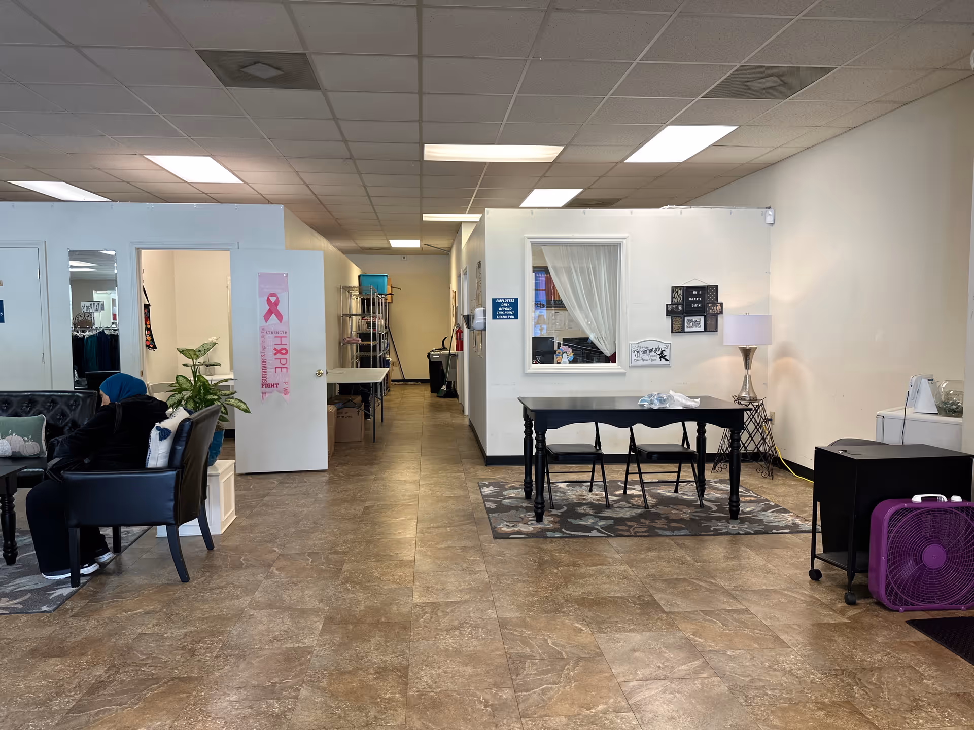 Spacious facility lobby with seating, a long table, and a reception window.