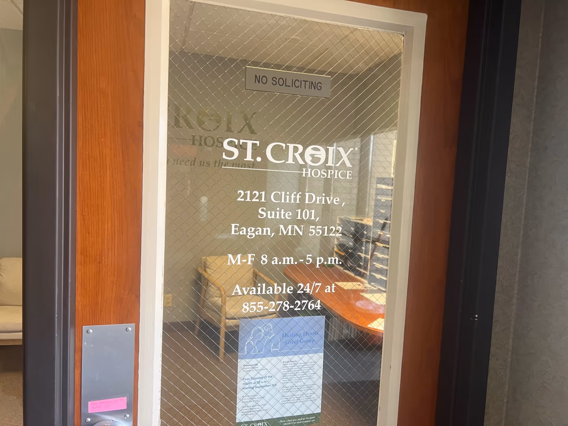 Glass door entrance with St. Croix Hospice signage and office furniture visible inside.