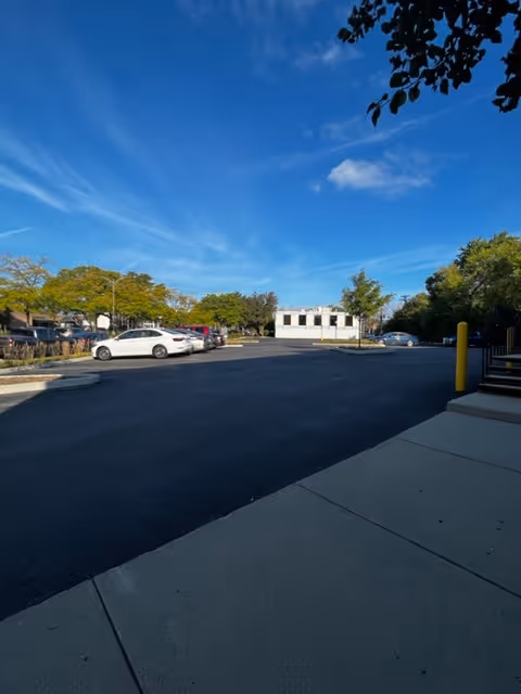 An empty parking lot in front of Prime Senior Home Care under blue sky.