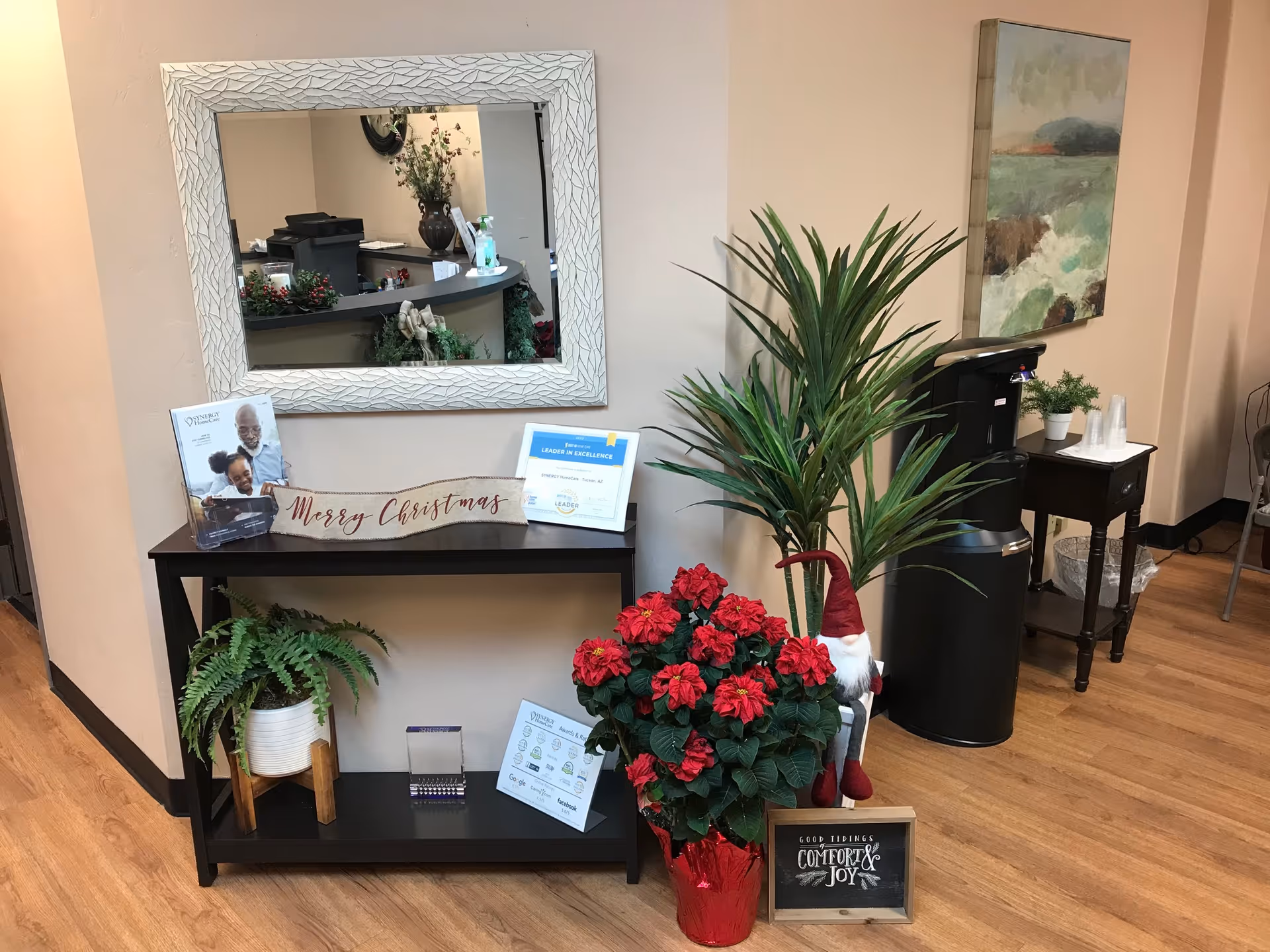 Interior reception area with mirror, plants, holiday decor, and a coffee station.