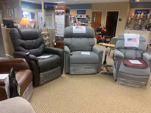 Three padded recliner chairs on display in a senior living showroom or lounge area.