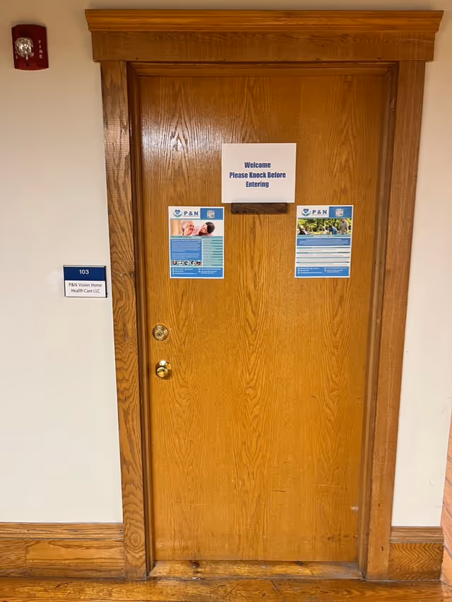 Wooden interior door in a hallway with welcome sign and posters.