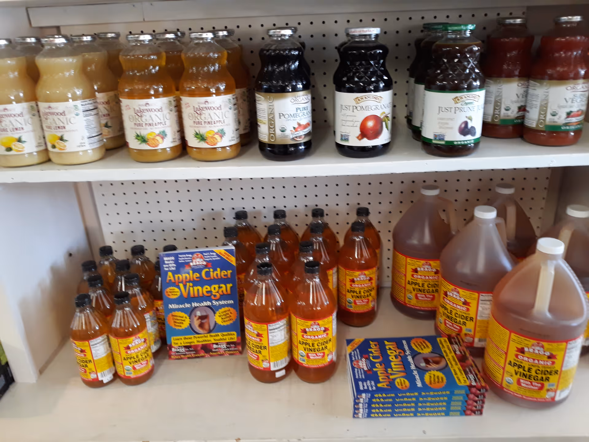 Interior shelves filled with various juice bottles and apple cider vinegar, no people visible.