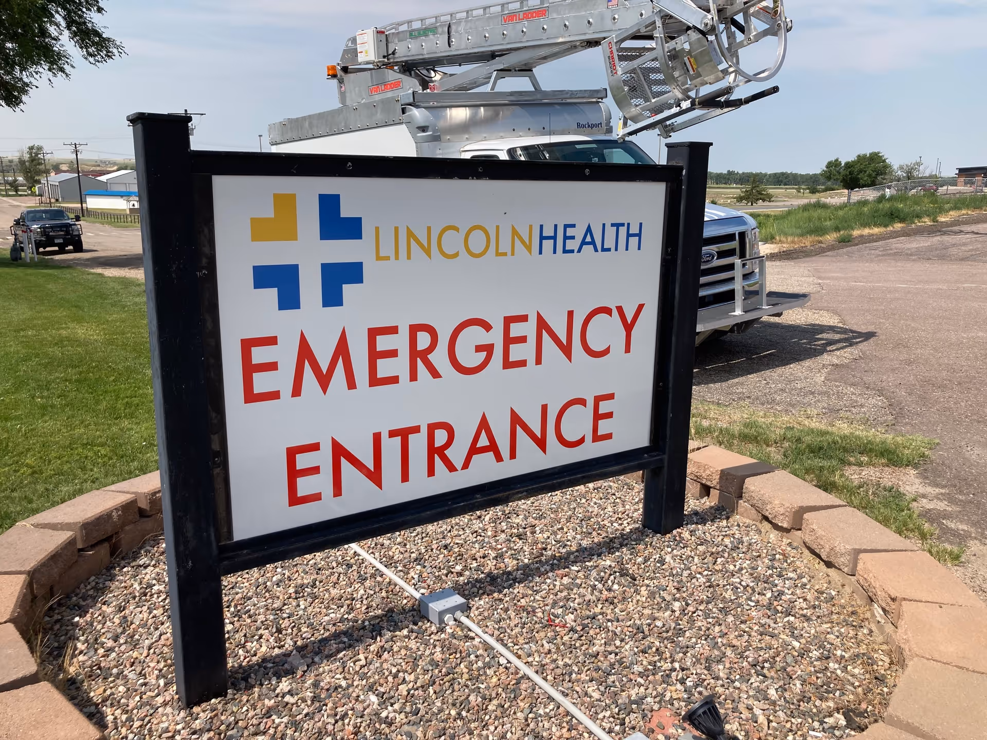 An outdoor Lincoln Health Emergency Entrance sign with a truck nearby.