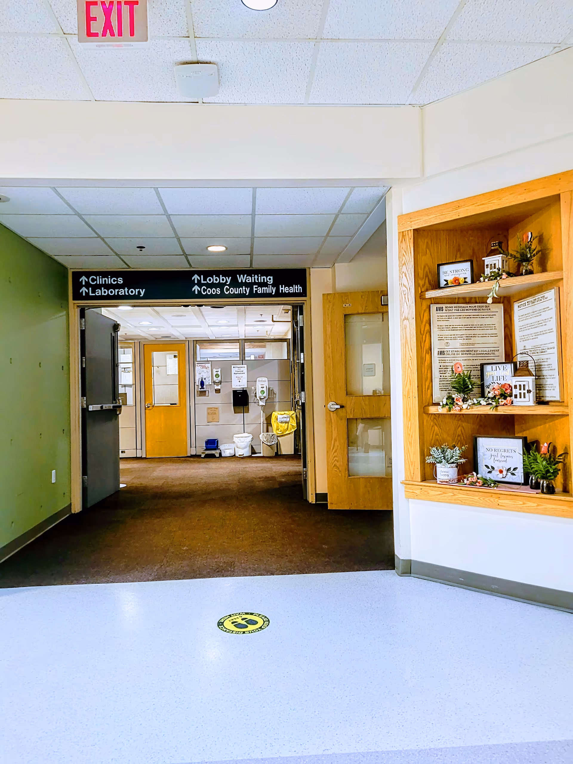 Androscoggin Valley Hospital hallway with doors, signage, and a display shelf