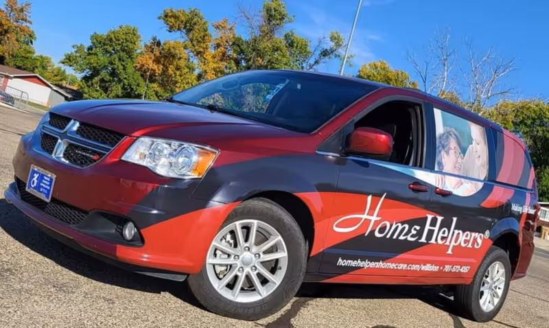 Brand-branded Home Helpers van parked outdoors with large side photo graphic