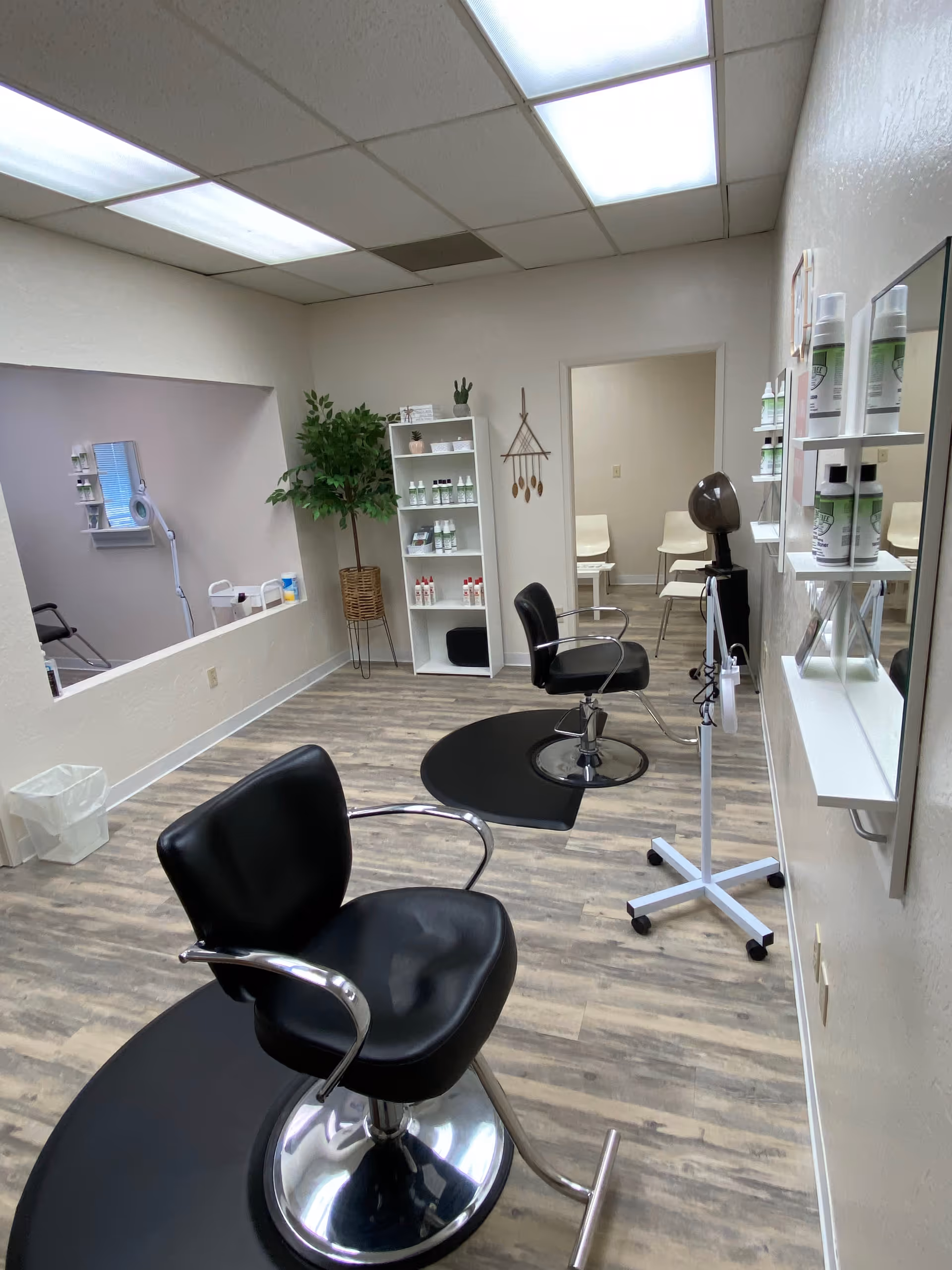 An empty hair salon in a senior living facility with chairs, mirrors, and shelves.