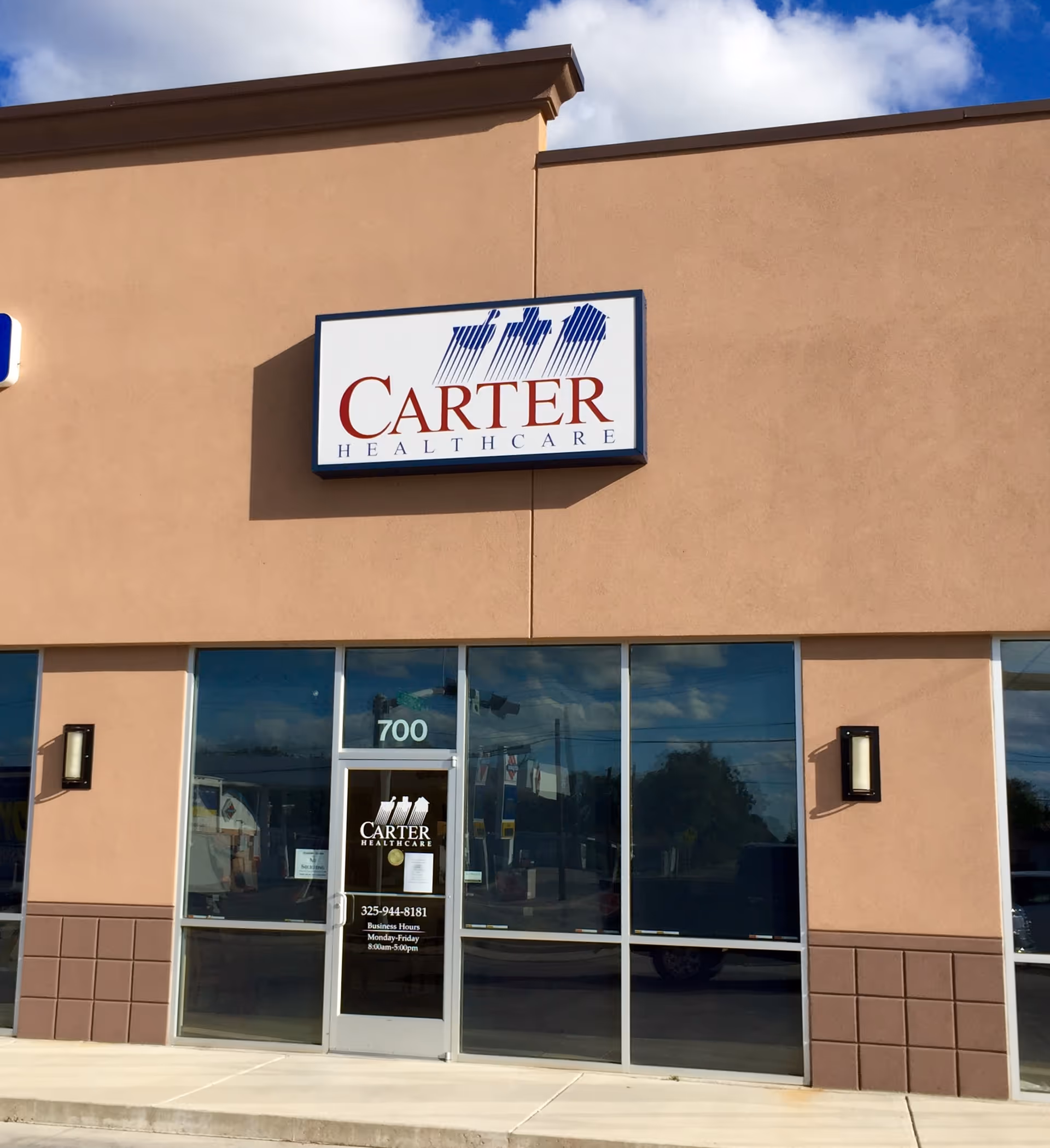 Front exterior of Carter Healthcare building with sign and glass entry doors.