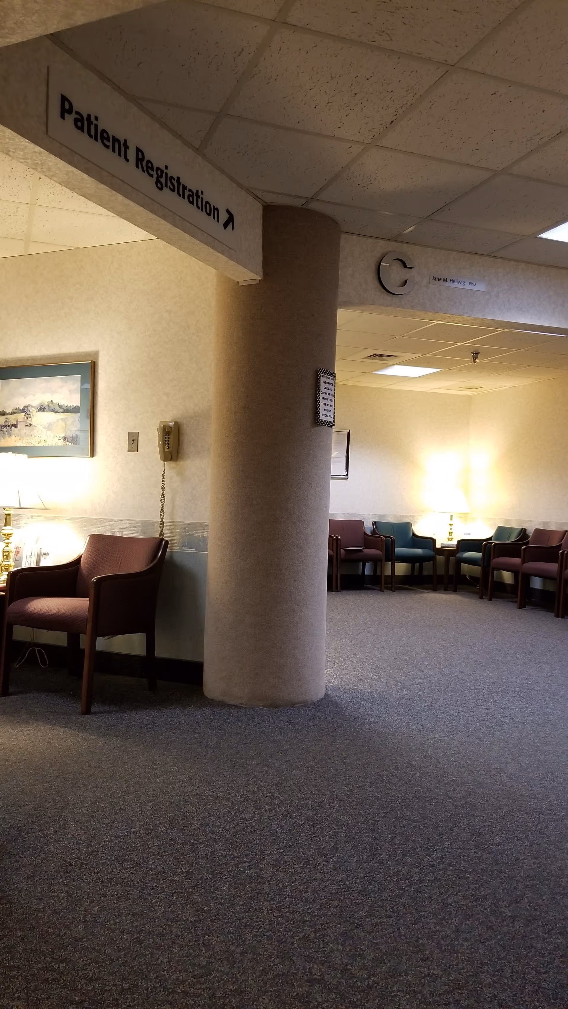 Lobby seating area features a large central pillar and a Patient Registration sign.