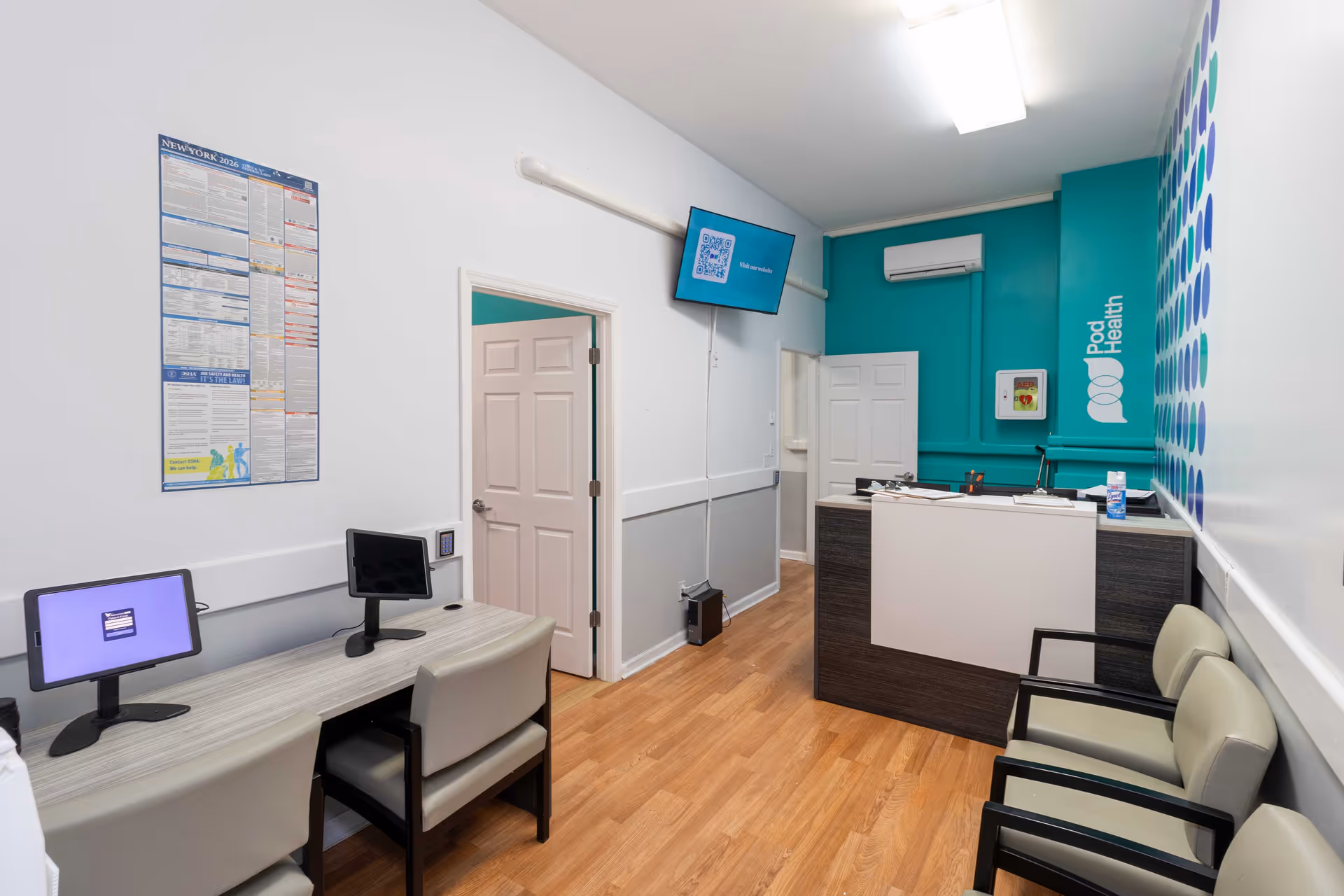Reception area with a dark wood desk, teal wall, and waiting chairs.