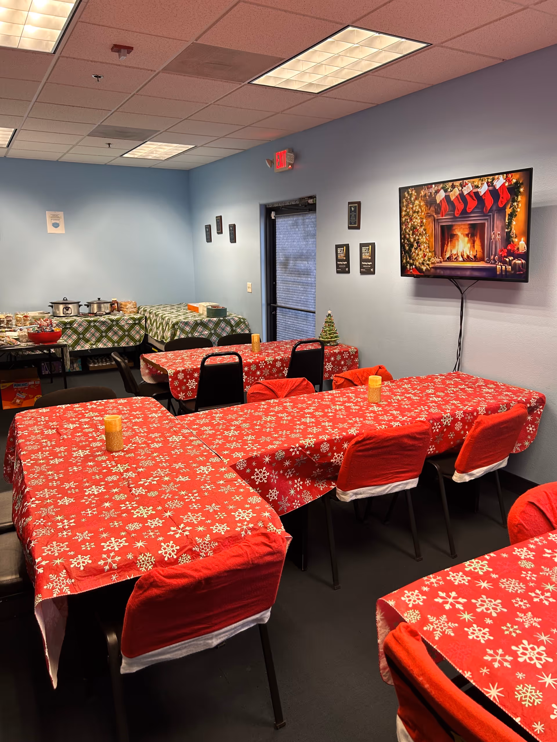 A holiday-themed dining room with red snowflake tablecloths and chairs.