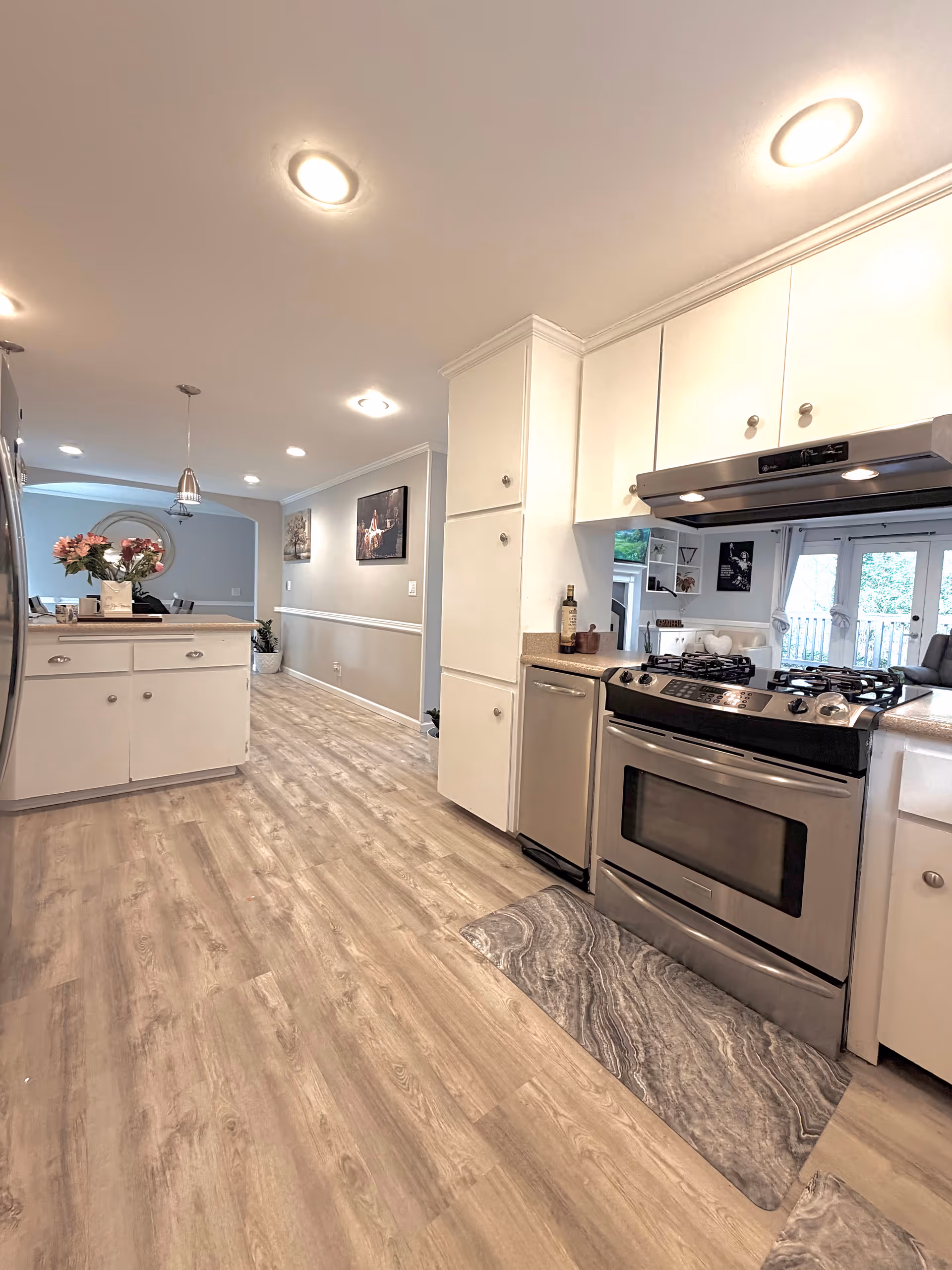 Bright, modern kitchen in a senior living facility with white cabinets and stainless steel appliances.