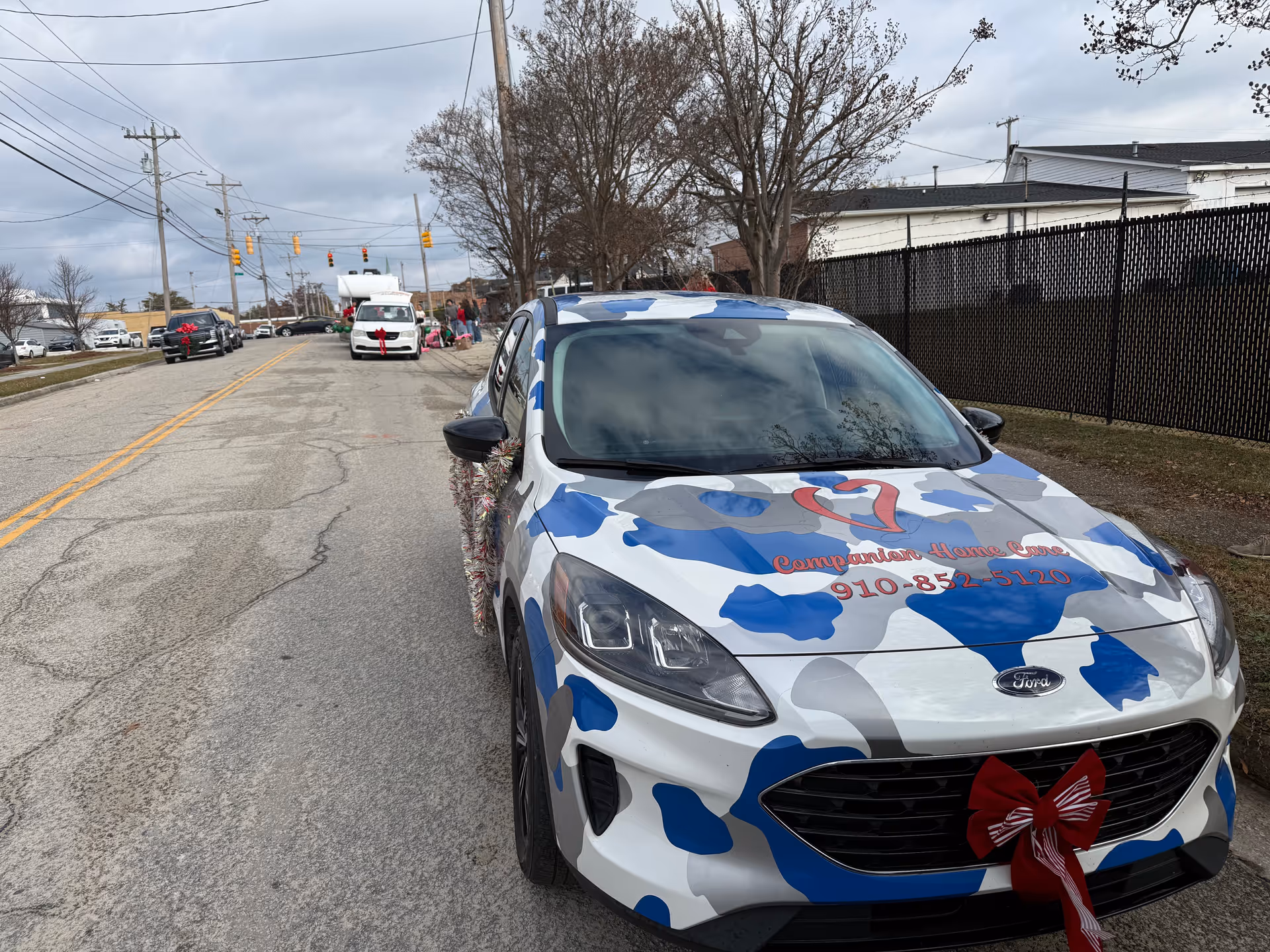 Decorated Companion Home Care vehicle parked on a street with a red bow.