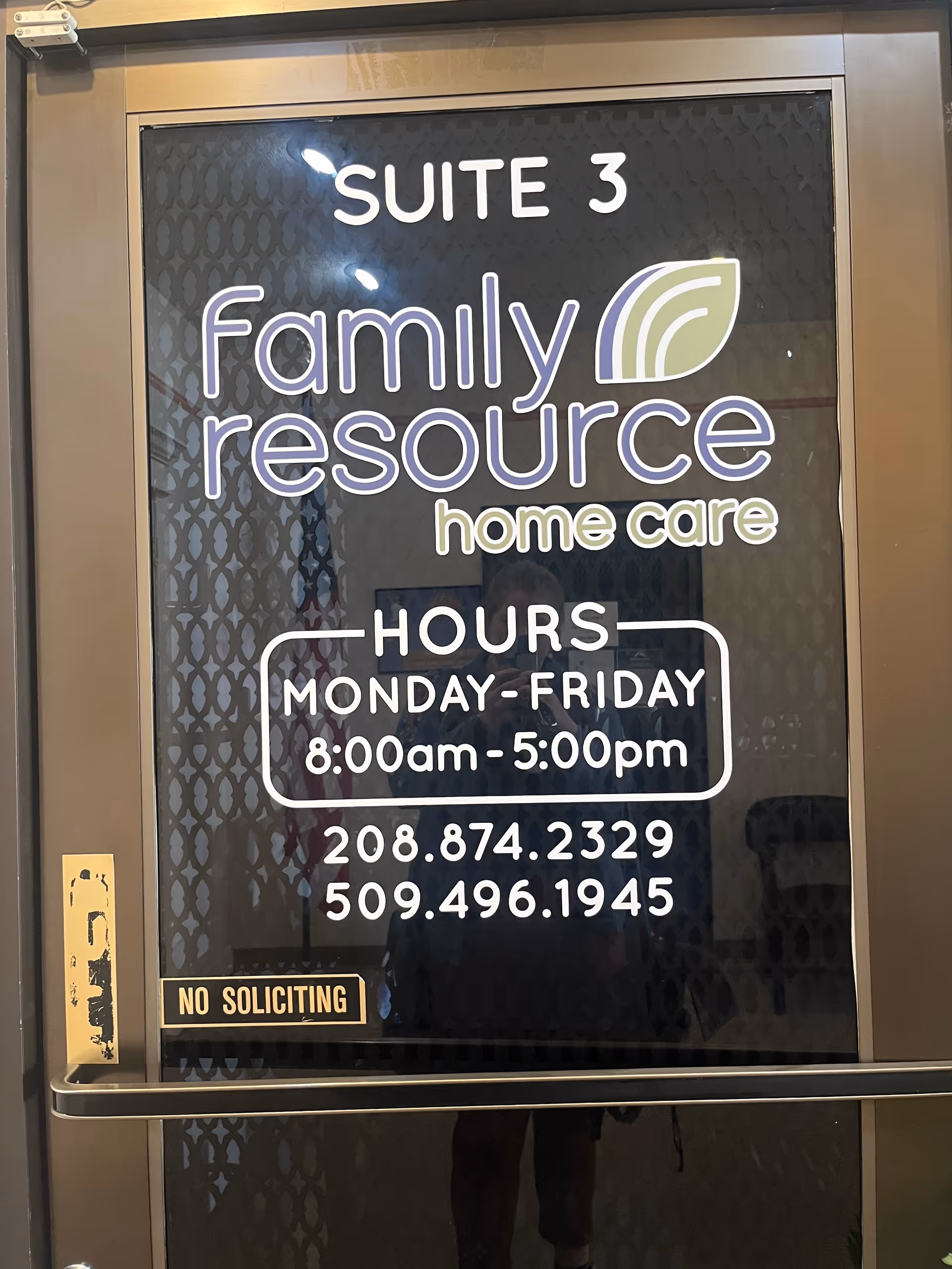 Glass door displays Family Resource Home Care sign with hours and phone numbers.