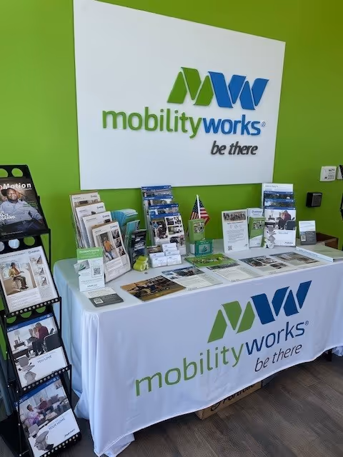 Bright lime-green interior with a MobilityWorks info booth and brochures on a table.