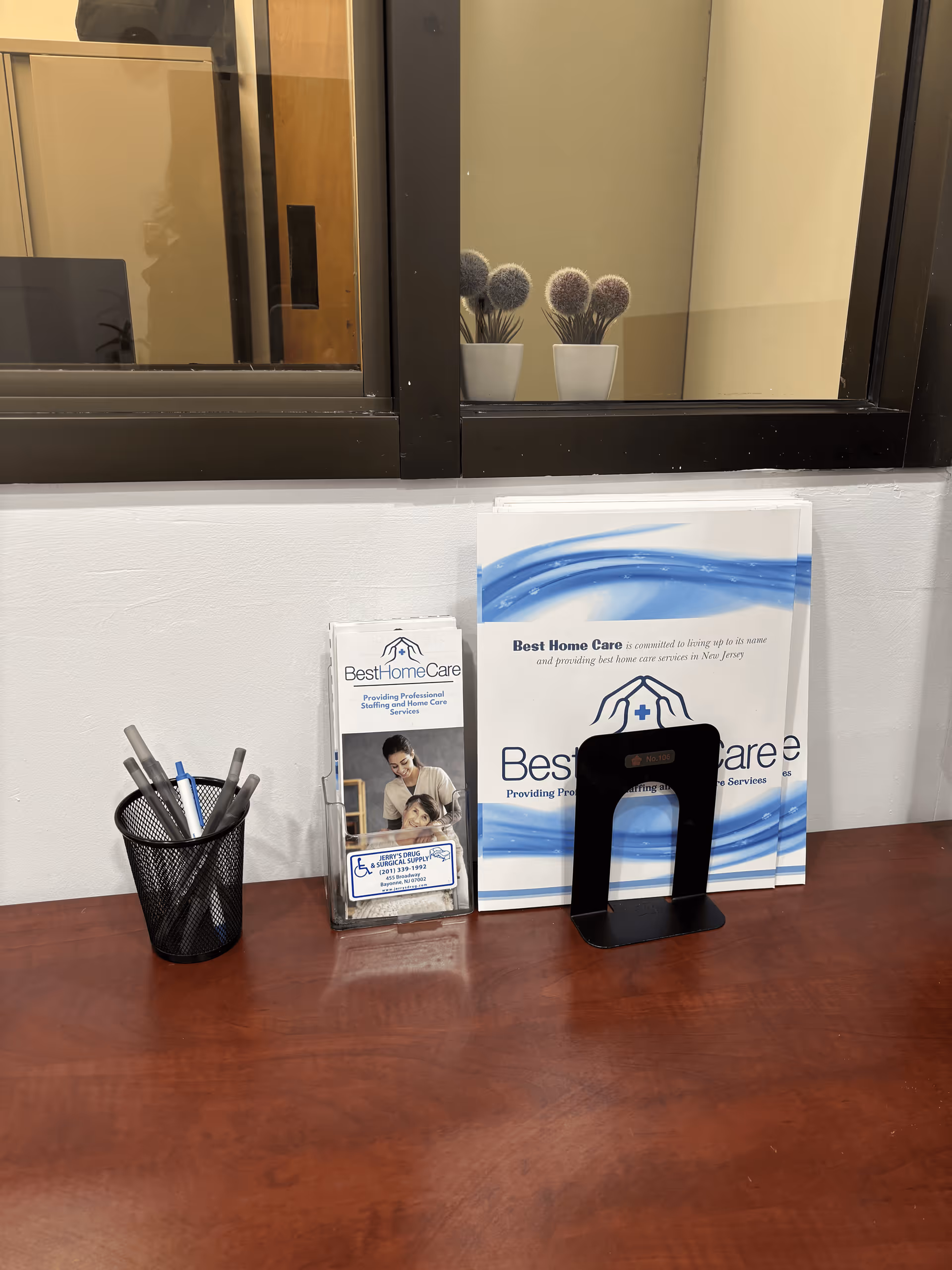 Desk with brochures, pens, and a brochure holder in a facility lobby.
