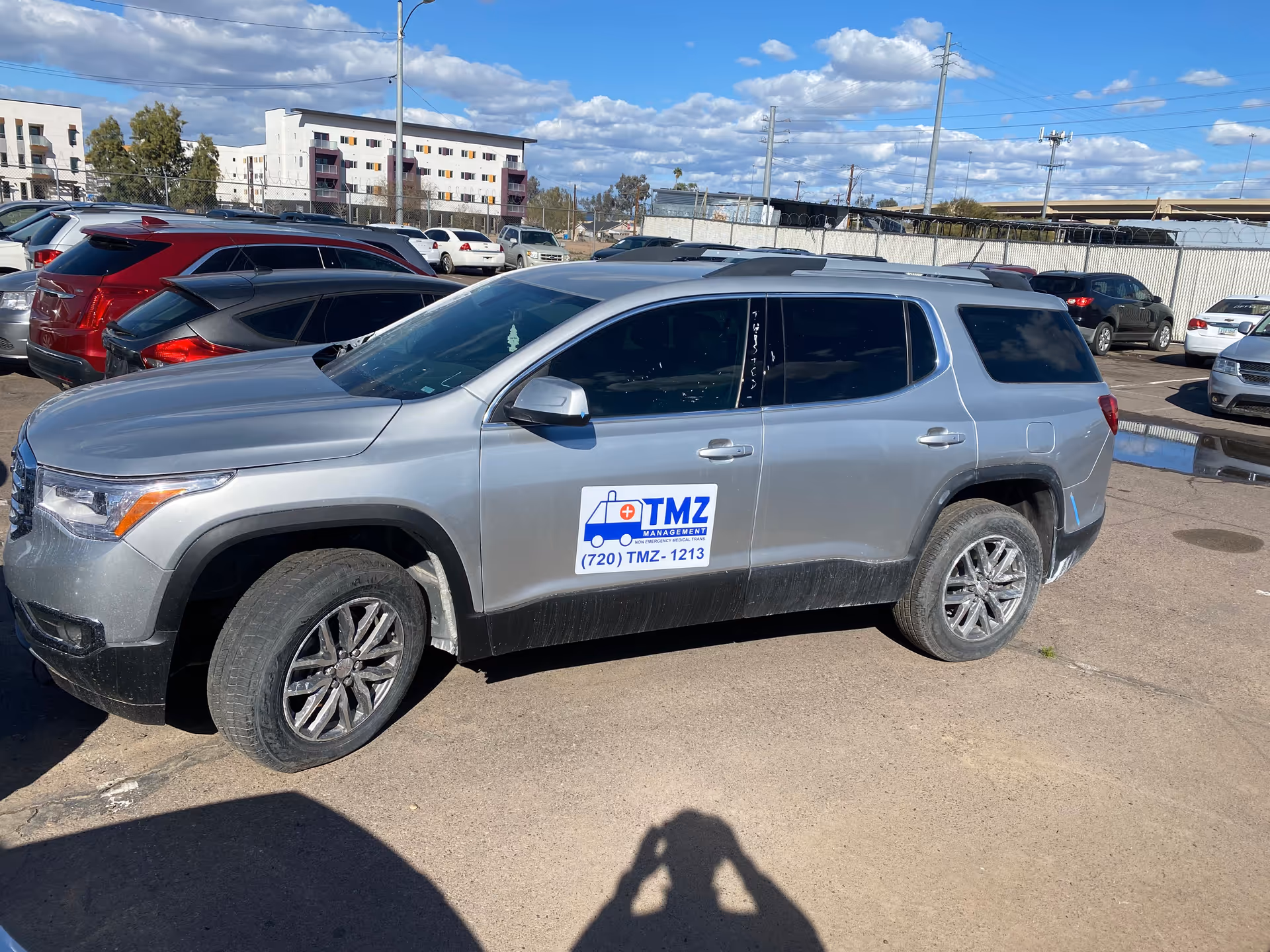 Silver TMZ Medical Transportation SUV parked in a lot beside other cars