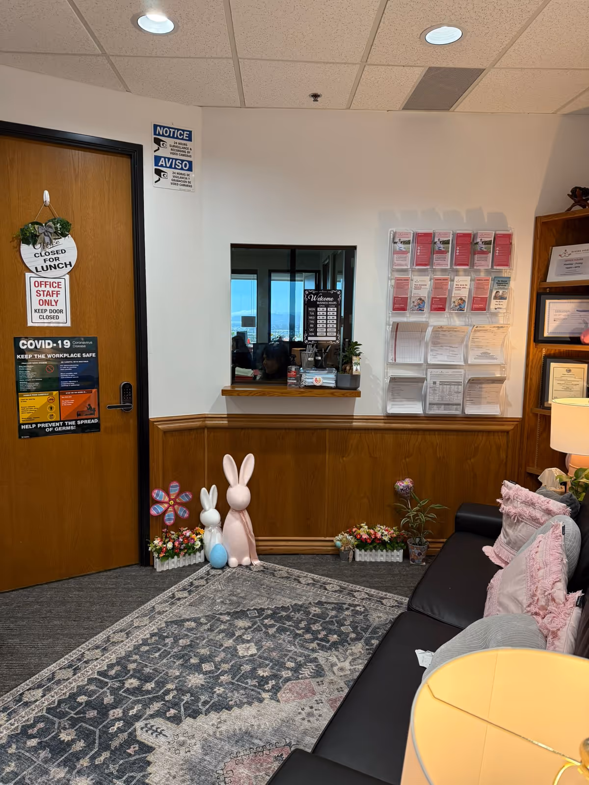 Interior lobby with wooden paneling, a sofa, bunny decorations, and wall-mounted flyers.
