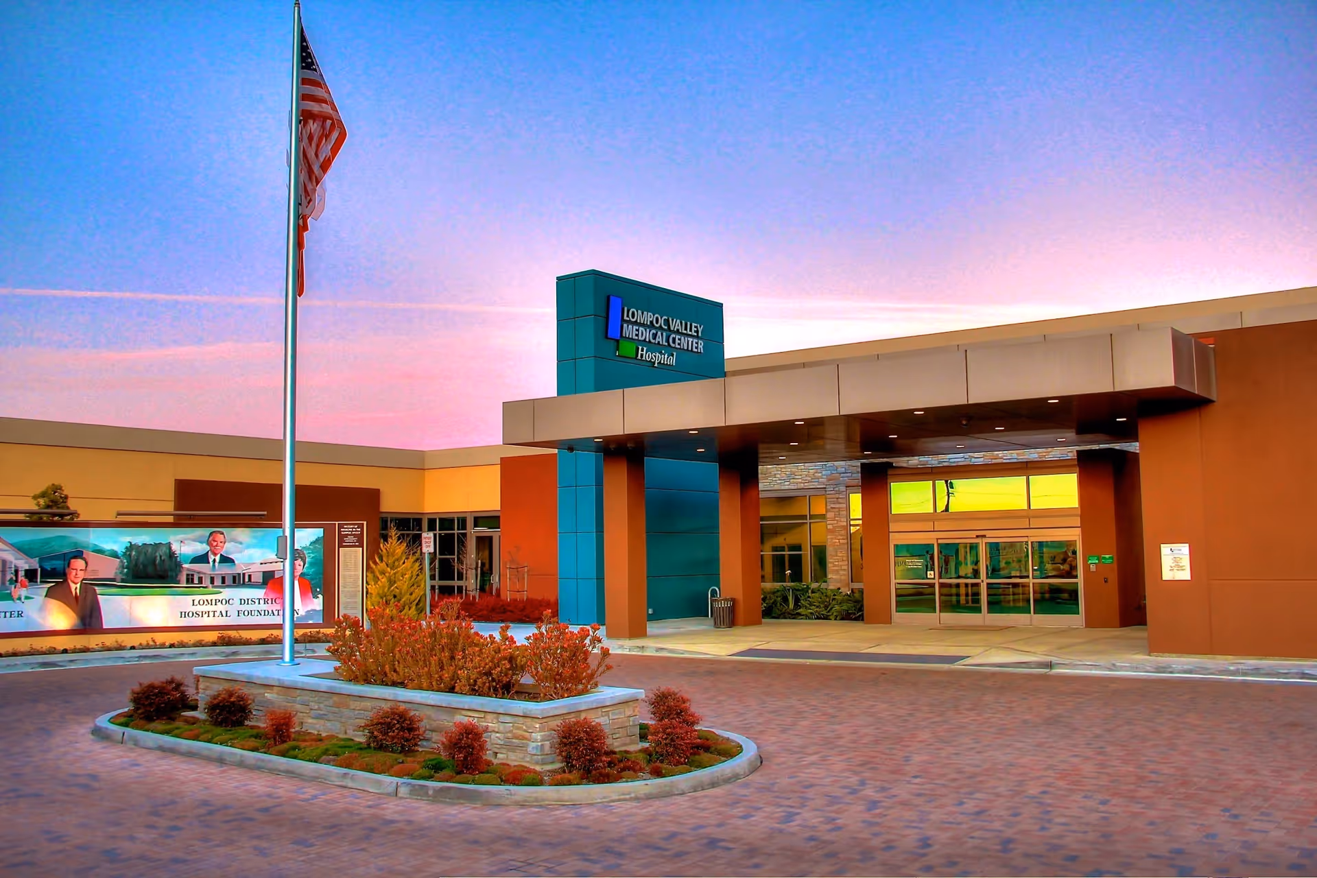 Lompoc Valley Medical Center entrance with flag and landscaped circular driveway.