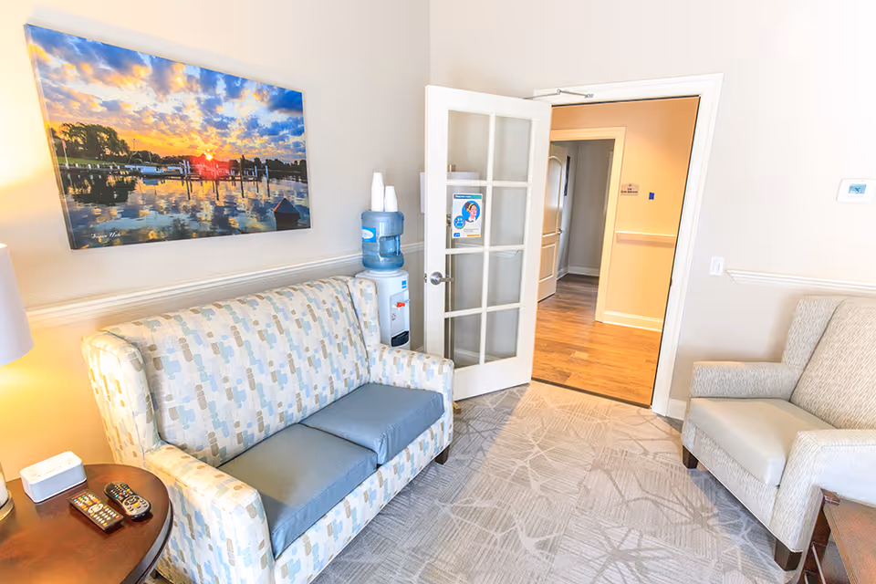 Cozy living room area with patterned sofa, wall art, and a glass-paned door.