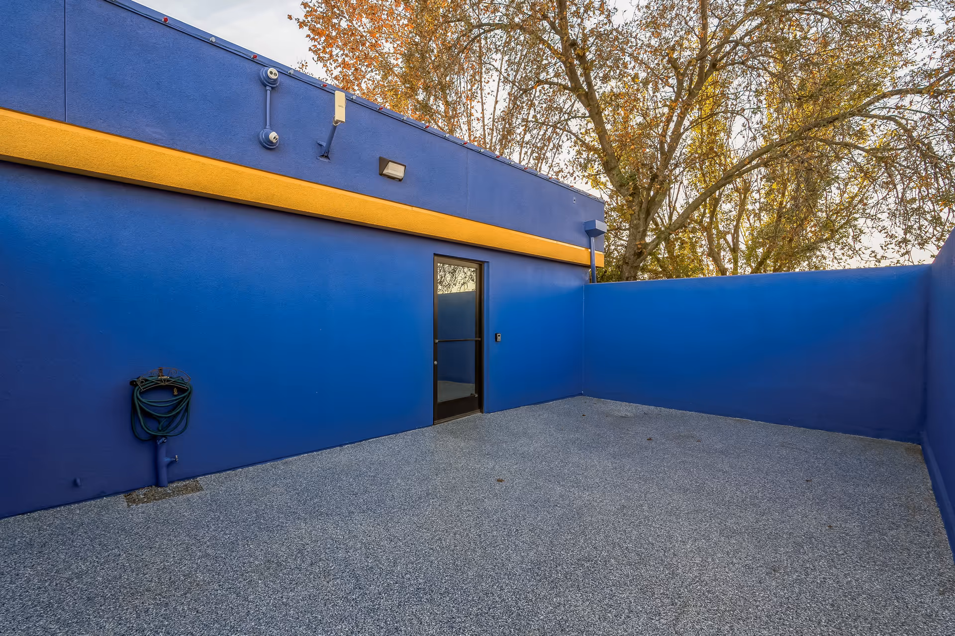 Blue exterior wall of a senior care facility with a doorway and courtyard.