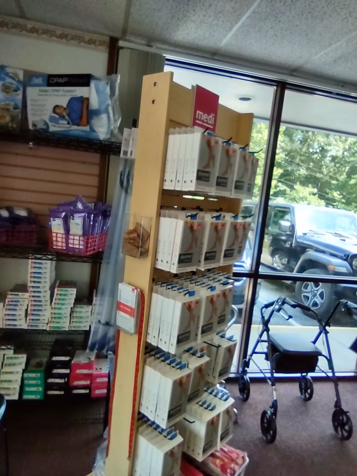 Inside a Lincare supply room with shelves of medical boxes and a wheeled walker nearby.