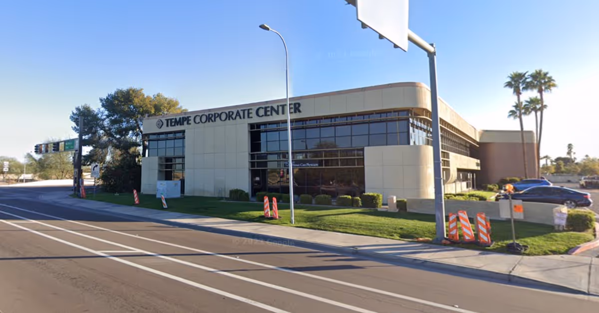 Exterior view of Tempe Corporate Center along a street with palm trees and cars