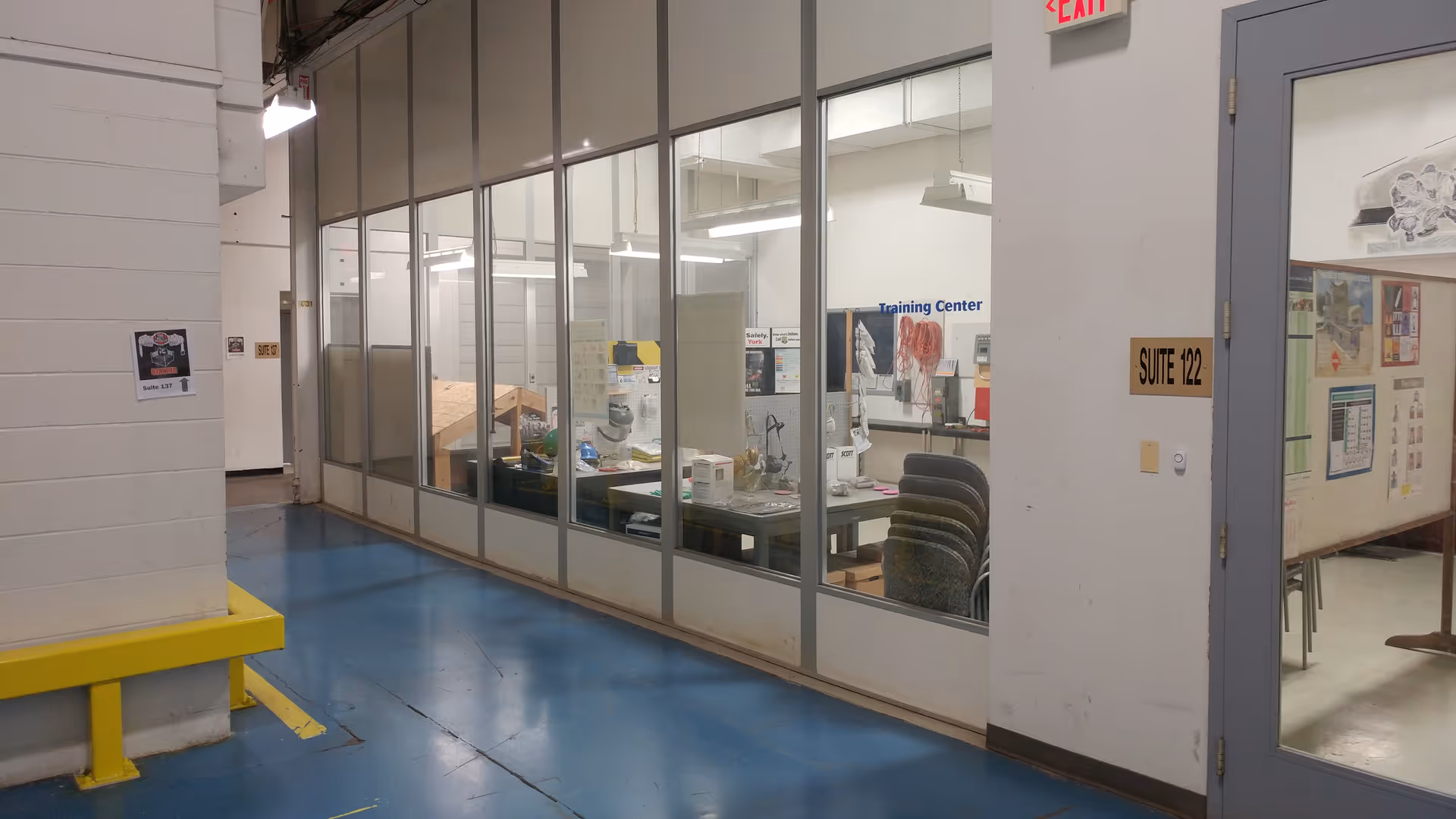 Glass-walled training center with desks and equipment visible through partitioned offices.