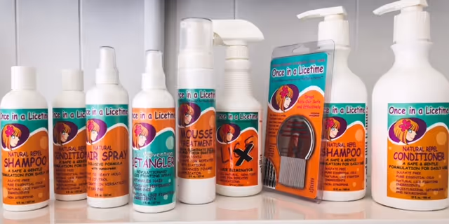 Shelf of Once in a Licetime lice treatment bottles inside an interior facility.