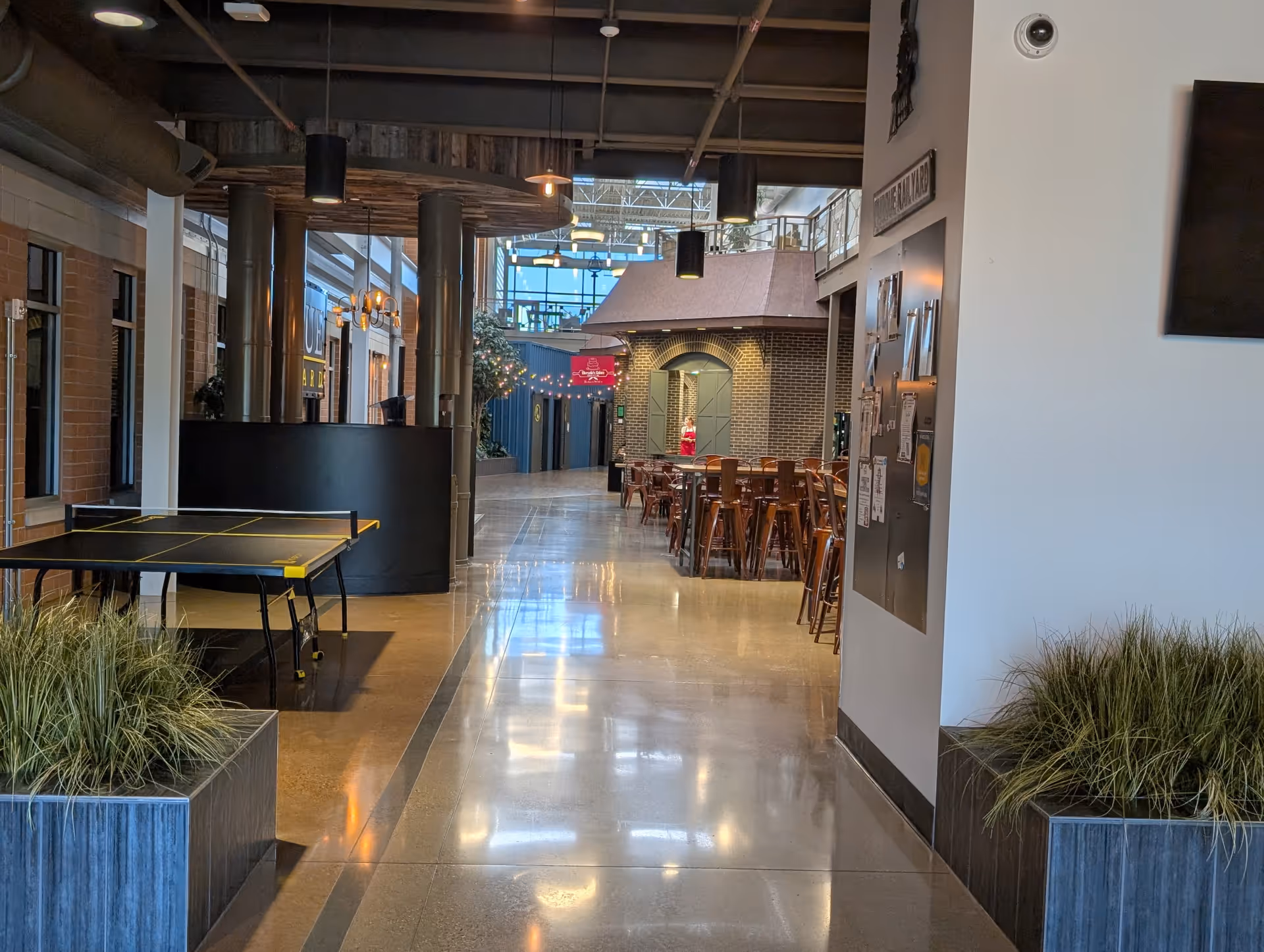 Indoor corridor of a modern senior living facility with a ping-pong table and seating.