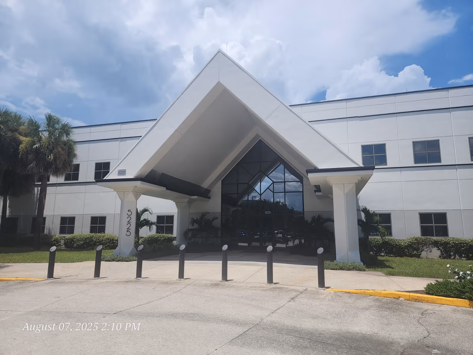 Modern senior facility exterior with a triangular front entrance and glass doors.