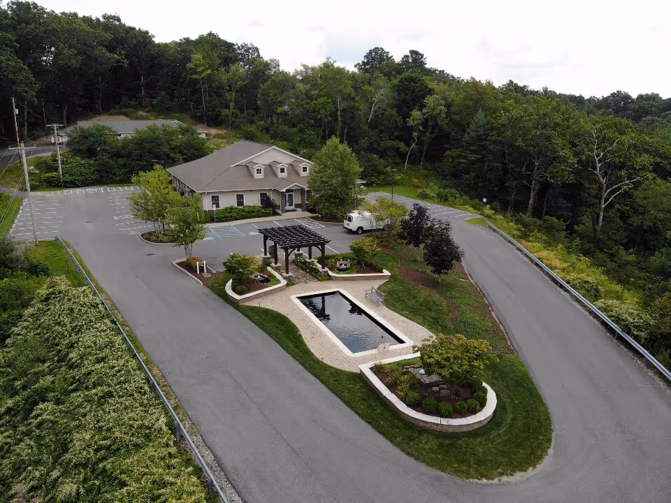 Aerial view of Hospice of Southern WV facility with landscaped entrance and fountain.