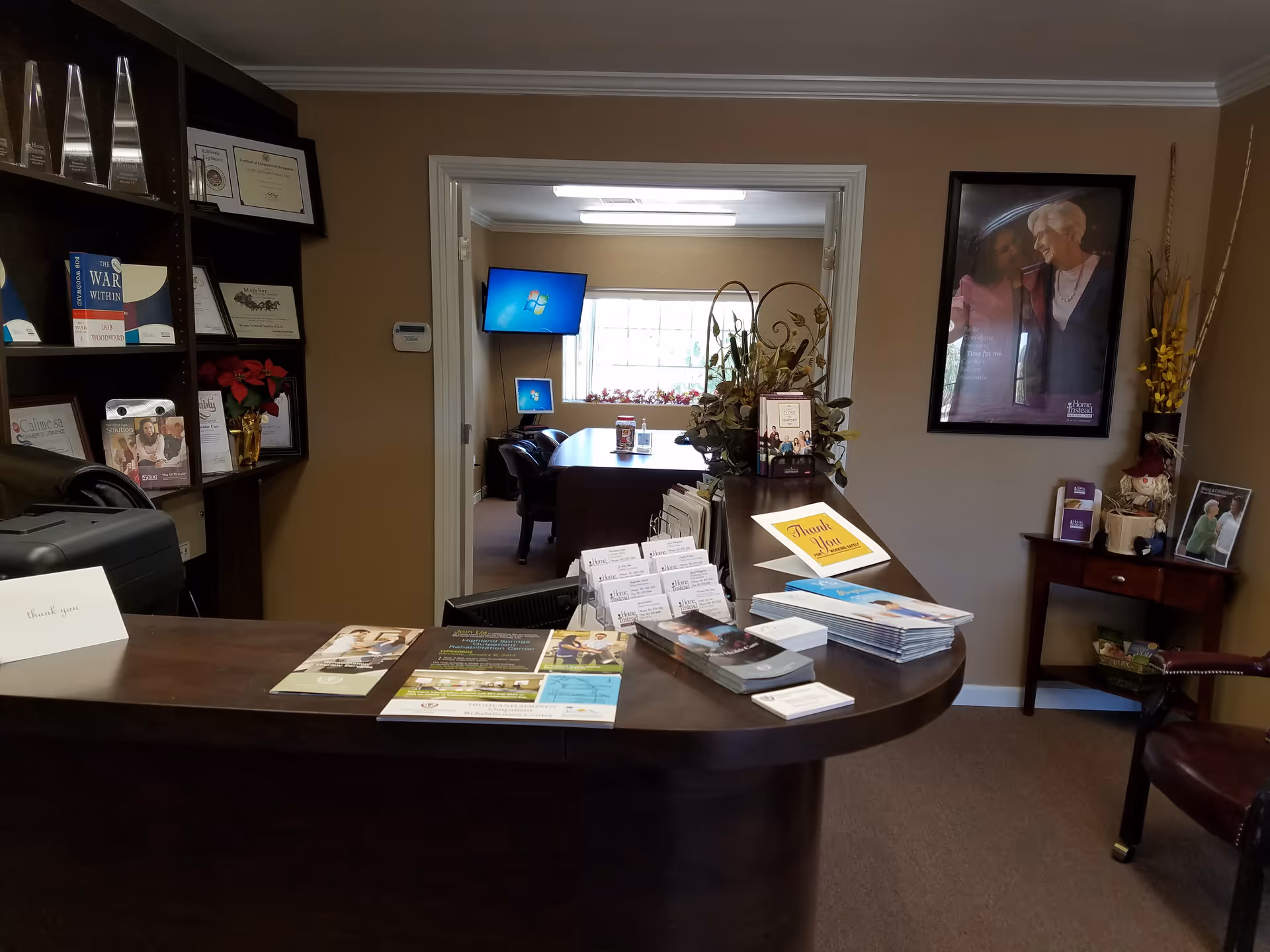 Reception desk in a warmly lit lobby with brochures and awards on shelves.