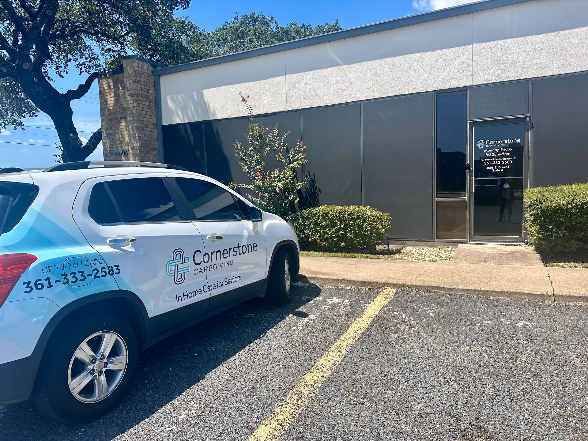 Exterior view of Cornerstone Caregiving building with branded car in the parking lot.
